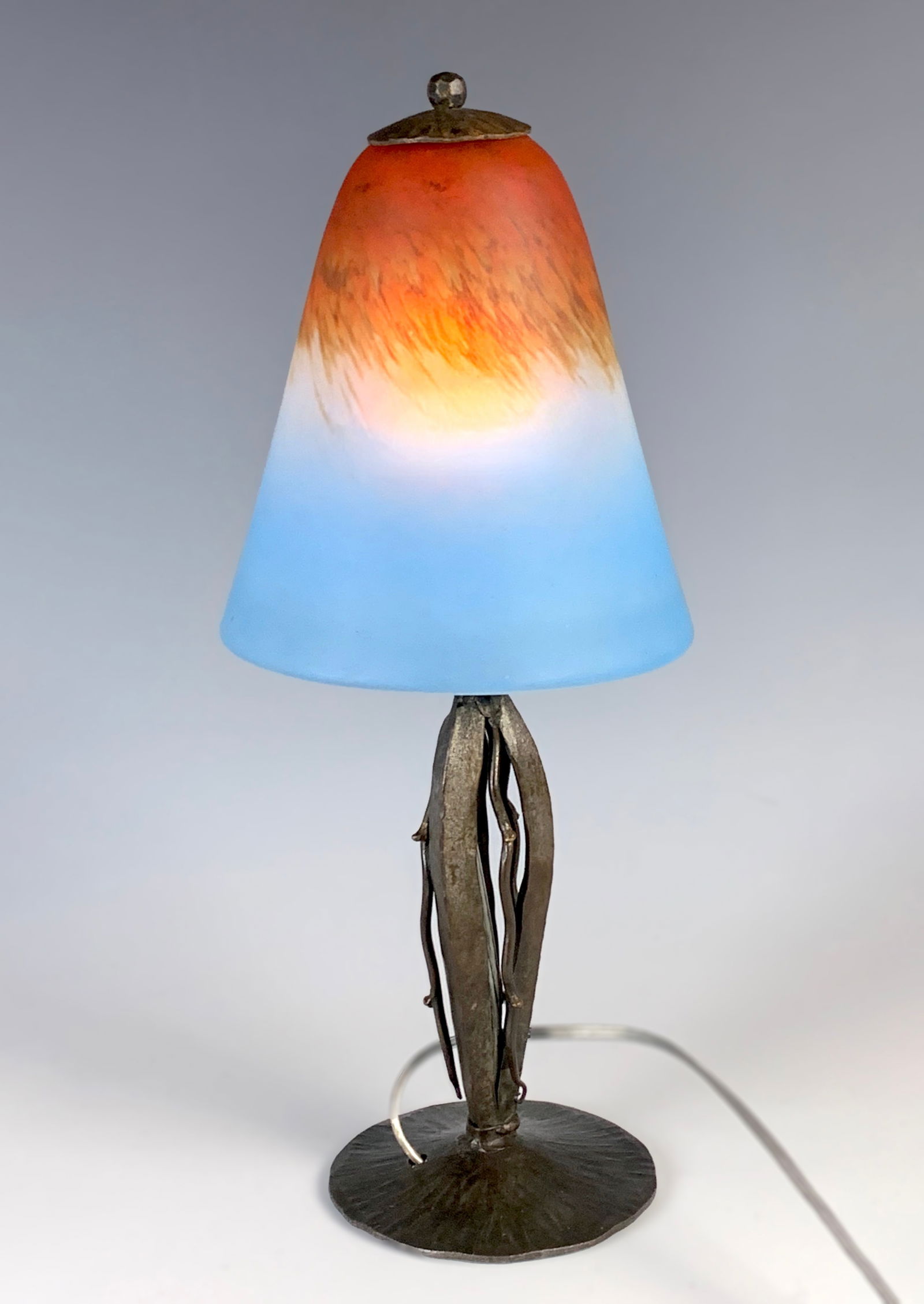 Schneider Art Deco Boudoir Lamp on Iron Base: Circa 1920, wonderful Art Deco boudoir lamp with a most unusual blue art glass shade with vermilion mottled top with blue and white, mounted on a wrought iron base, rewired with U.S. electrical, very