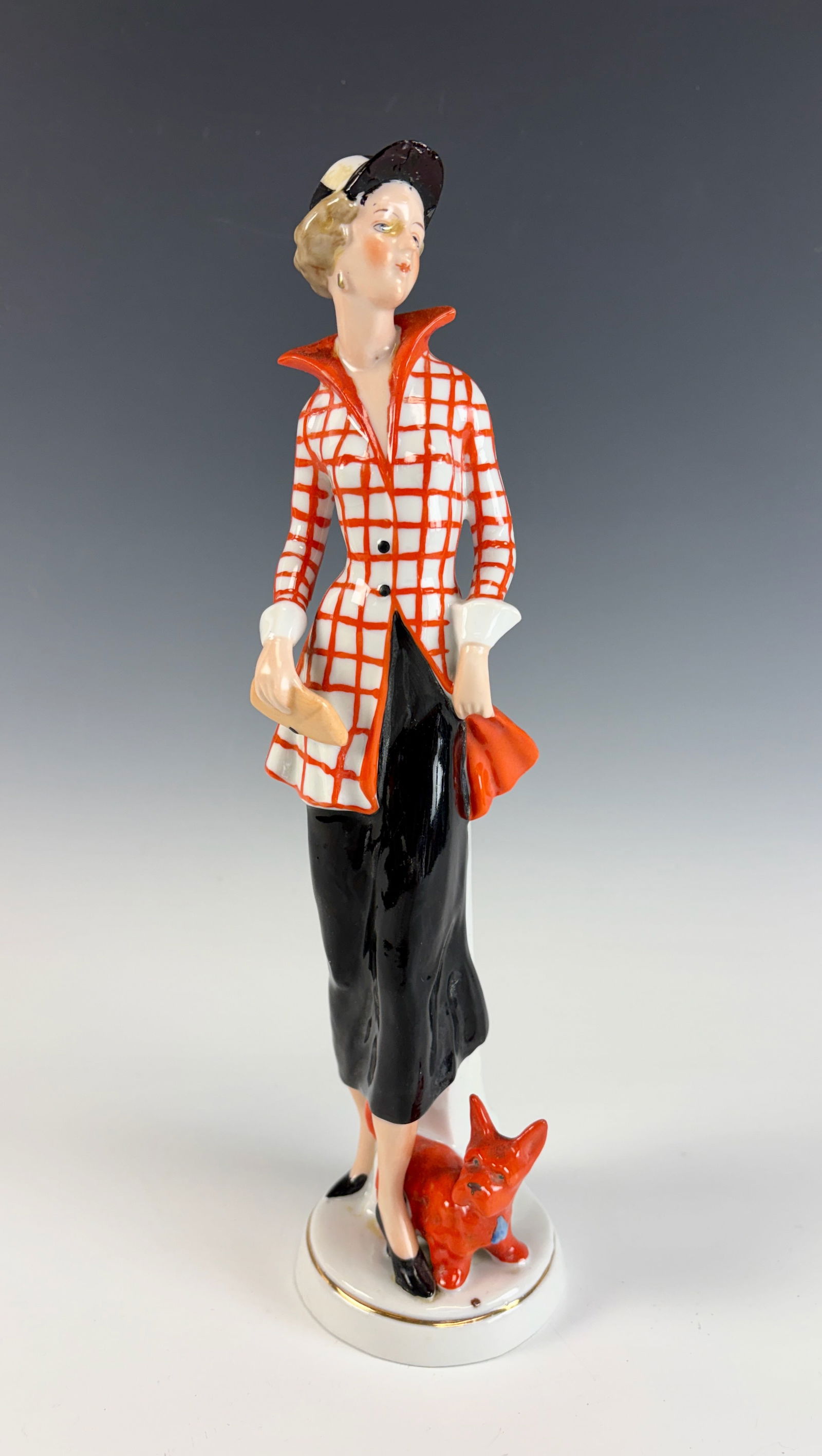 Art Deco Porcelain Figurine Lady & Her Dog: A fine porcelain Art Deco figurine depicting a lady with her dog, dating to the 1920s. Marked on the bottom with a crown over the letters F.R. and serial number 26446. The piece bears a sticker statin