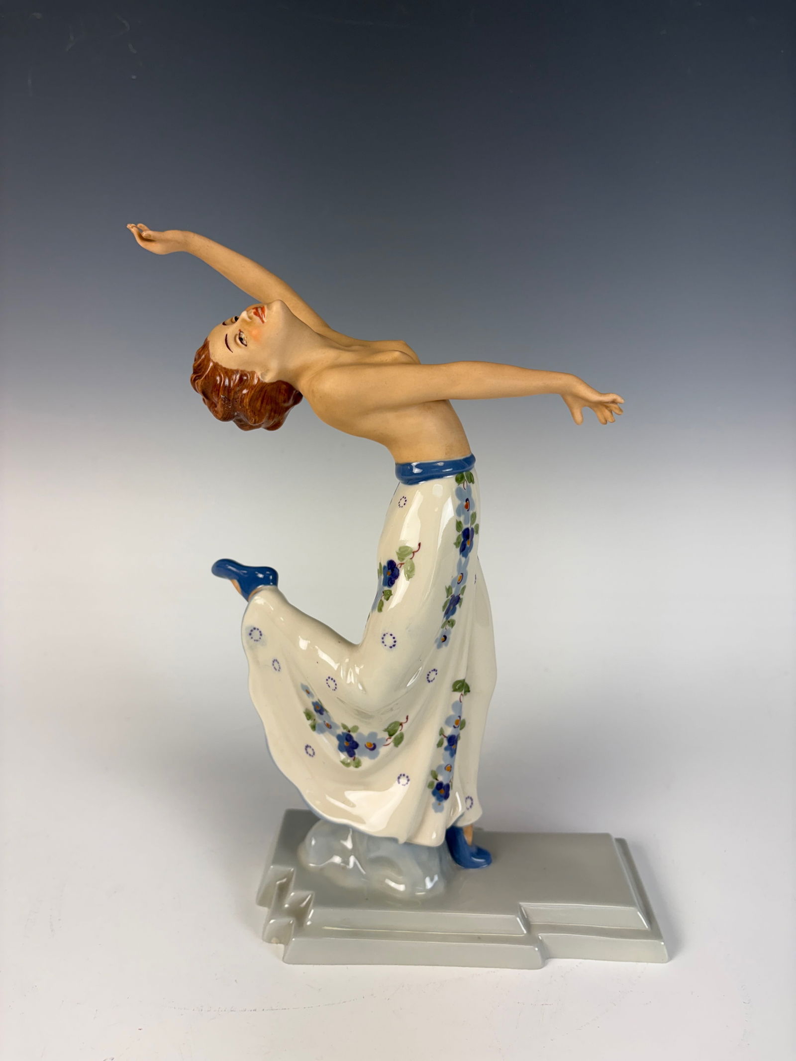 Royal Dux Art Deco Dancing Girl Figurine: A striking Art Deco figurine depicting a topless lady with an arched back, crafted in polychrome porcelain with the Royal Dux pink triangle mark. 10.5” tall × 7” wide × 3” deep. In