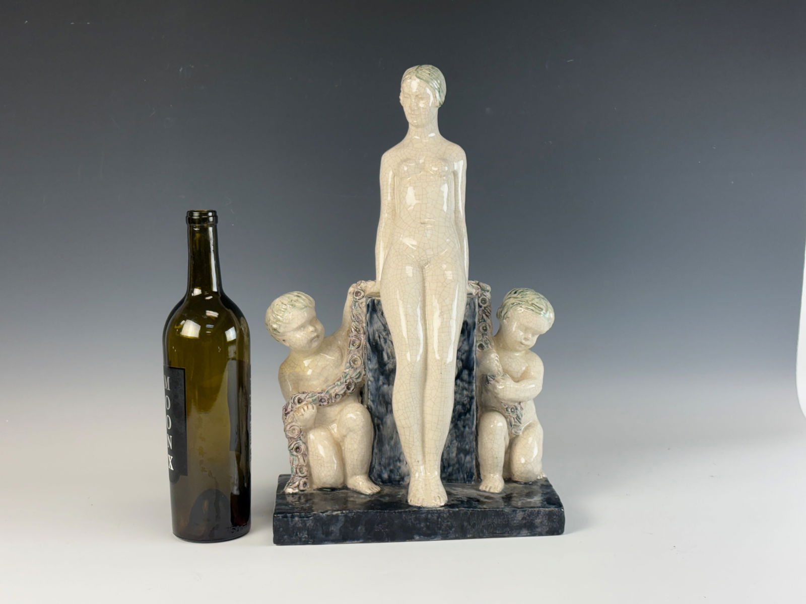 Louis Fontinelle Woman w Swans Art Deco Figurine: An Art Deco white and crackle-glazed earthenware figurine depicting a nude woman accompanied by two swans. Louis Fontinelle (1886–1972) created this piece in France, numbered 85, and signed L. Fonti