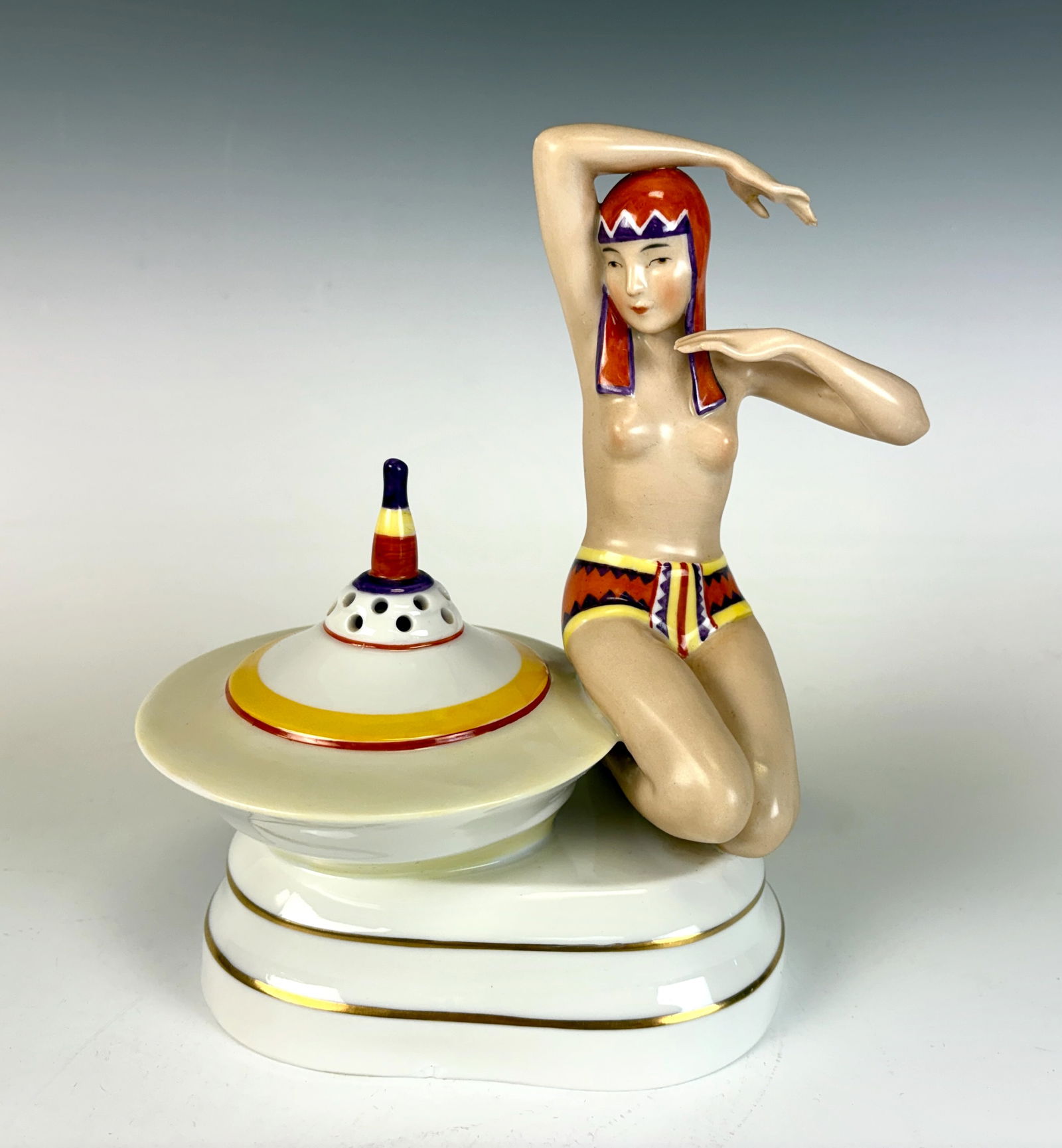 Heubach Koppelsdorf Aladin Perfume Lamp: A charming German made perfume lamp depicting a 1920s Art Deco lady seated beside a porcelain burner fitted for a light bulb. Excellent condition overall, missing socket. Signed Heubach – Aladin. 8&