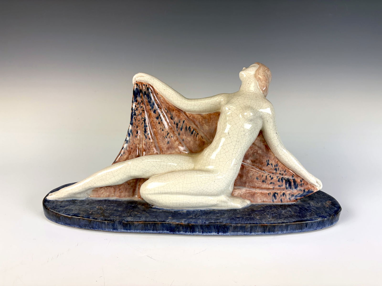 Fernand Guinier Art Deco Nude Woman Figurine: A fine earthenware Art Deco figurine depicting a nude woman draped with a shawl, dating to the 1920s. Fernand Guinier (1902–1972) signed the piece. 8.5” tall × 16.25” wide × 5” d
