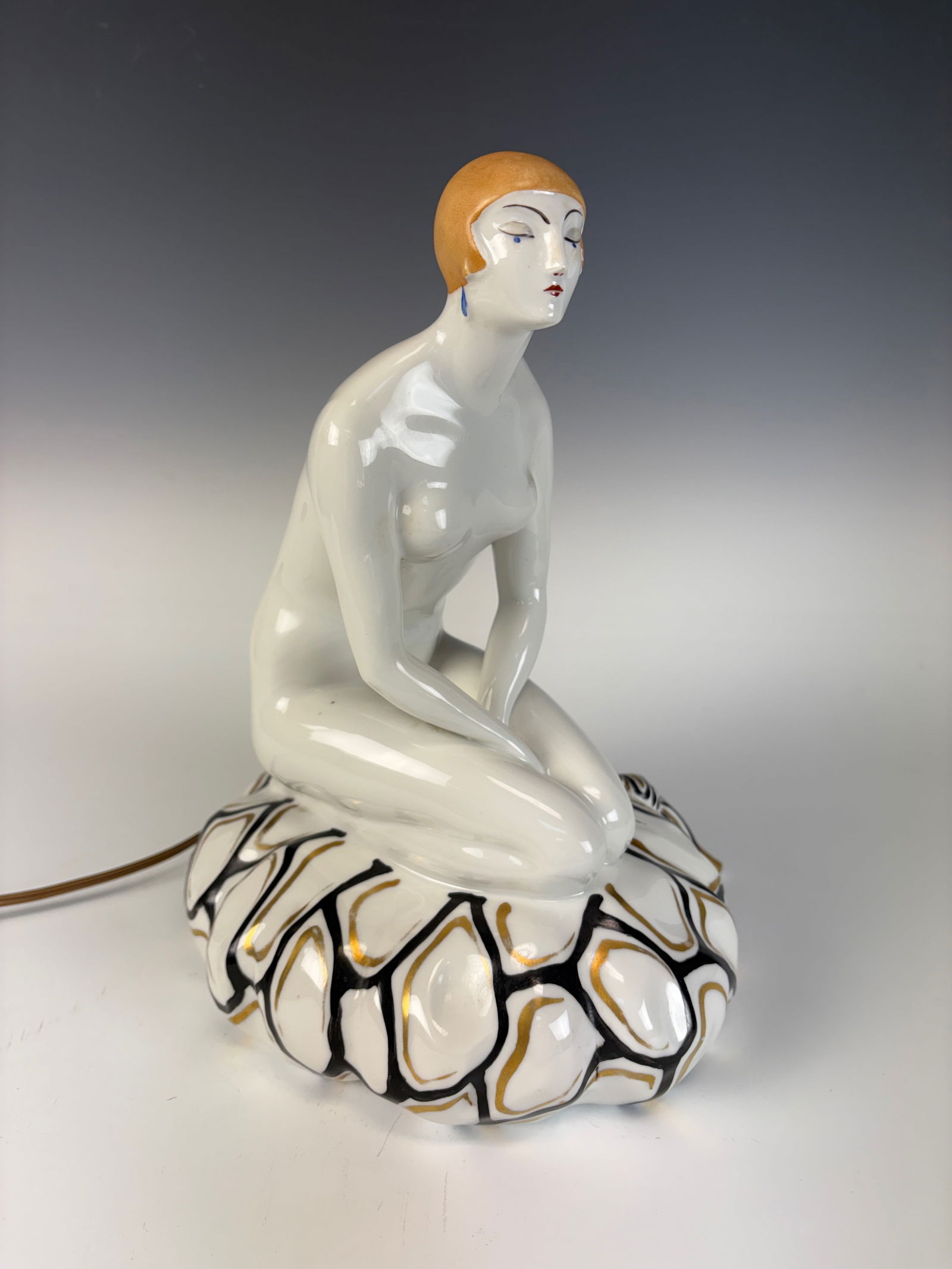 Jean Boyer Art Deco Woman Nightlight, Limoges: Jean Boyer (1919–1988) A large enameled porcelain Art Deco nightlight depicting a young woman kneeling on a cushion. Created in Limoges, circa 1920s, this charming piece combines elegance and functi