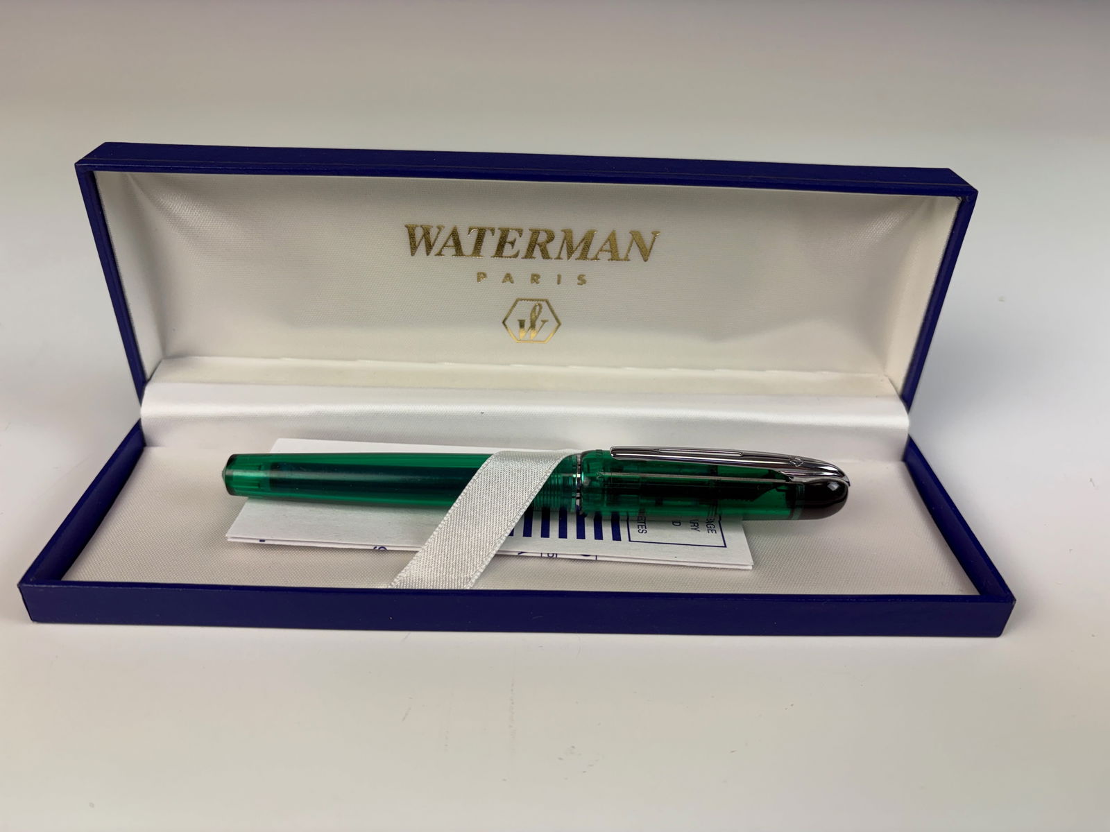 Waterman Acrylic Fountain Pen: A Waterman fountain pen with a green transparent acrylic case, accompanied by its original blue box marked Waterman Paris. 5.25” long. In good condition.
