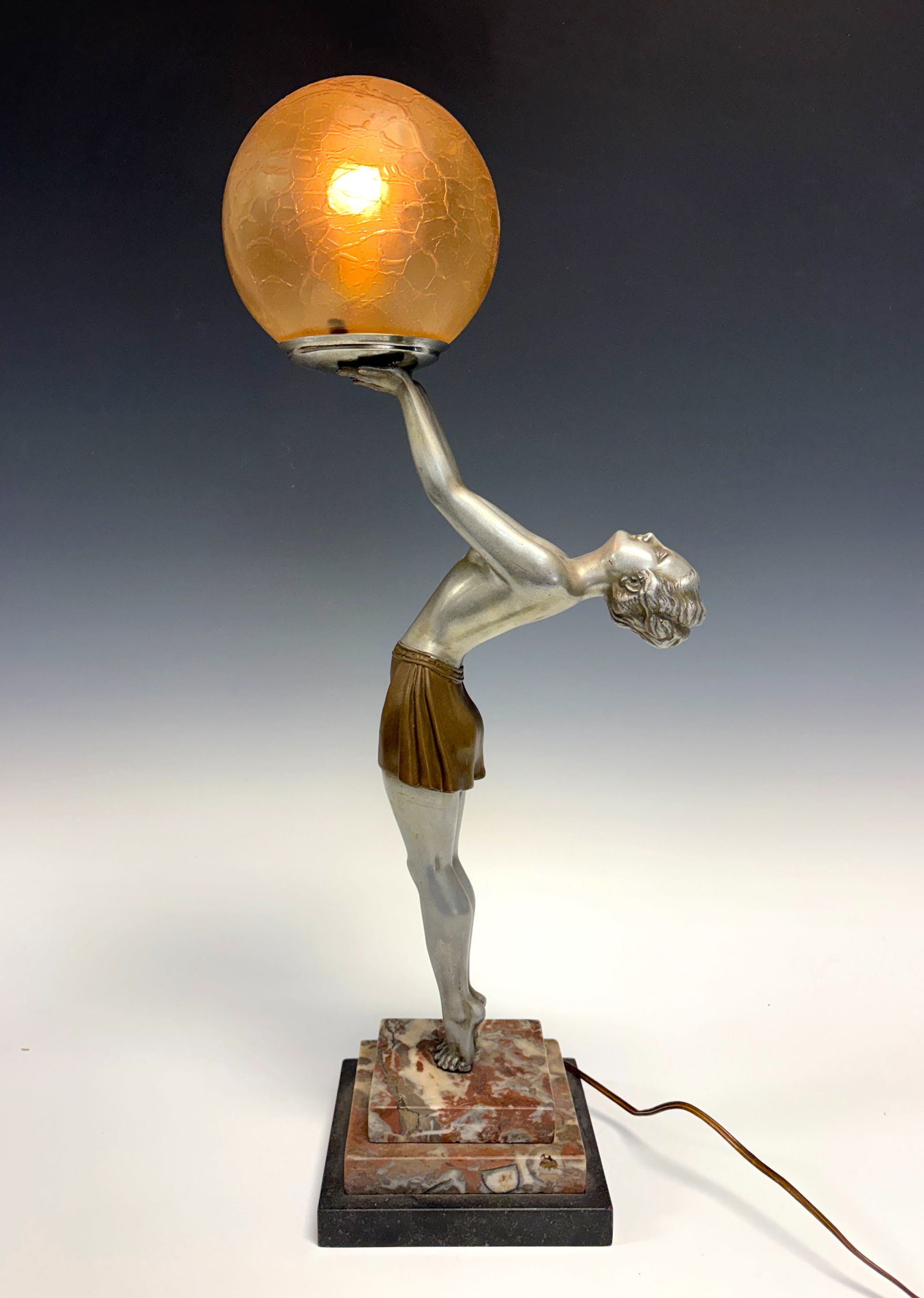 Enrique Molins-Balleste Art Deco Figural Lamp: A circa 1935 Art Deco figural lamp by Enrique Molins-Balleste, signed on the foot. The spelter lamp depicts a topless lady leaning back supporting a luminous globe-shaped shade above. Art Deco at its