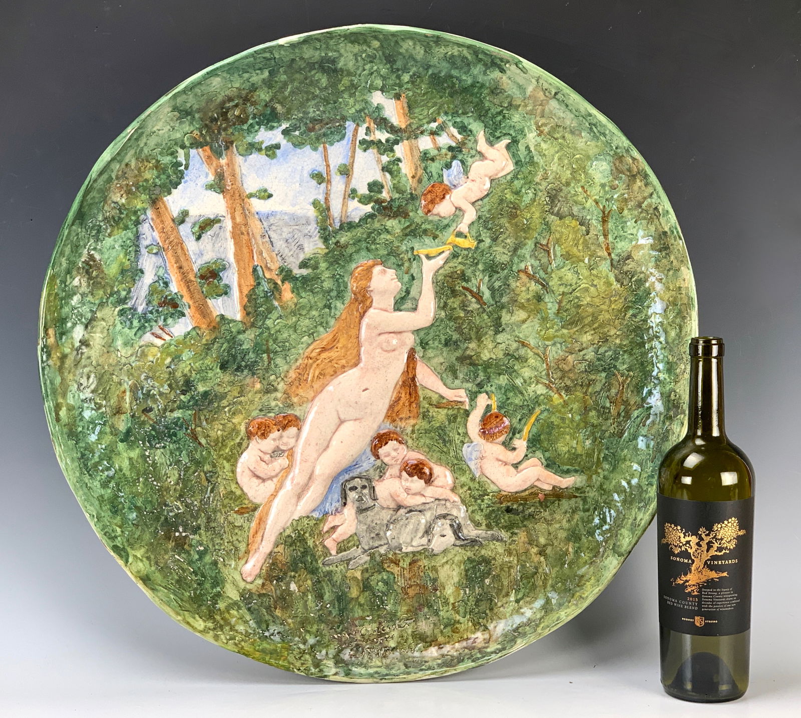 Max Claudet "Nymph & Cherubs" Ceramic Plaque: Circa 1820s, Max Claudet (1840-1893) large impressive ceramic plaque with raised relief scene by listed sculptor Max Claudet, of circular form, decorated with a nude lady receiving a libation from a c