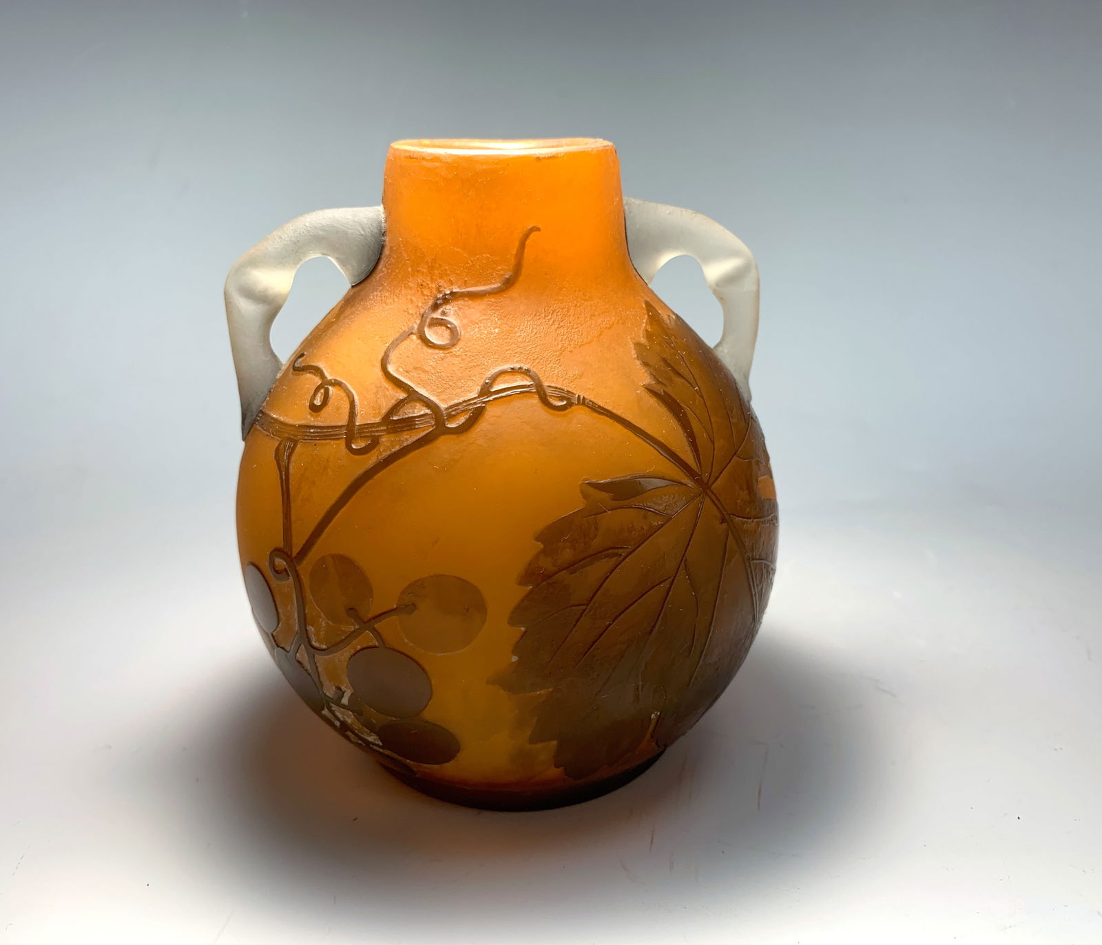 Delatte Nancy Cameo Art Glass Handled Vase: Cameo glass vase with deep brown flowers on orange ground with two applied clear frosted glass handles, signed "A. Delatte Nancy", 4.75" tall, good condition