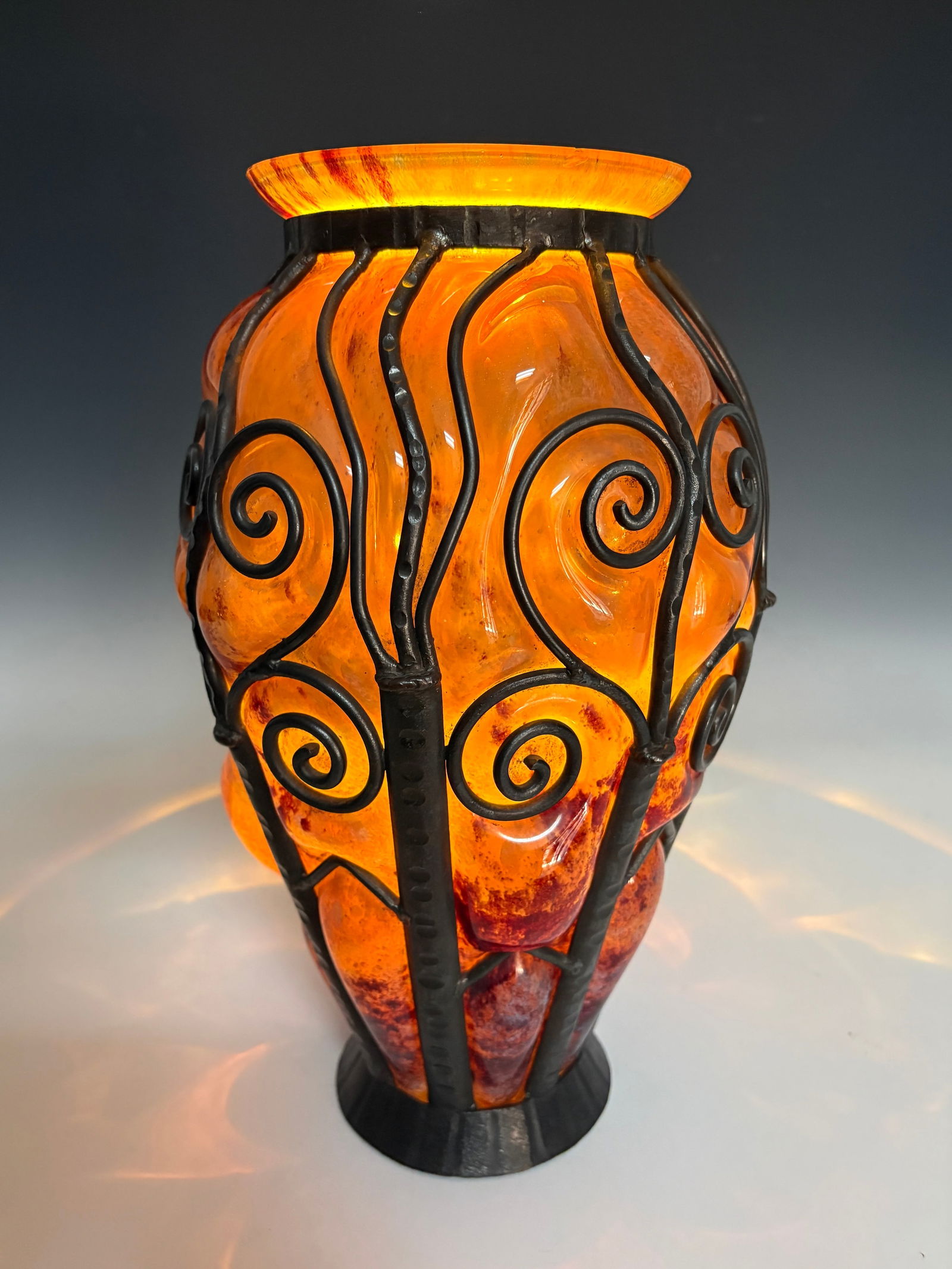 Glass & Iron Blowout Art Deco Vase Sgd Lorraine: Circa 1920s. Large Art Deco vase in mottled orange glass encased in wrought iron swirl designs. Verreries d'Art Lorraine was made by Daum. Very good condition, 14.5" tall.