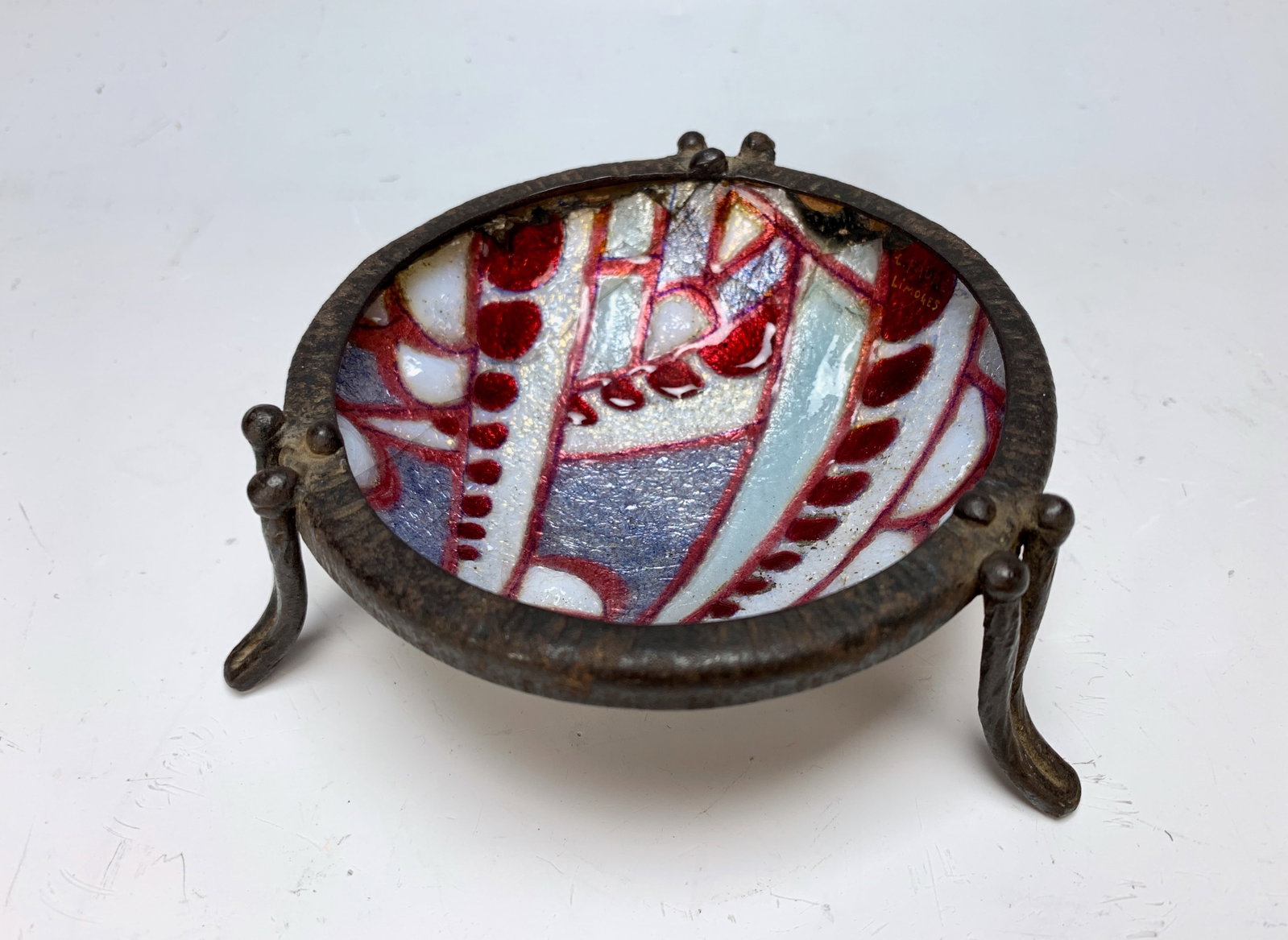 Camille Faure Art Deco Enamel Dish: Camille Faure (French 1874-1956) Circa 1930, a great art deco enameled dish in with red, grey and white, set into a 3 legged wrought iron frame, signed "C Faure Limoges" 1.5" x 4.75" (4cm x 10cm) , ha