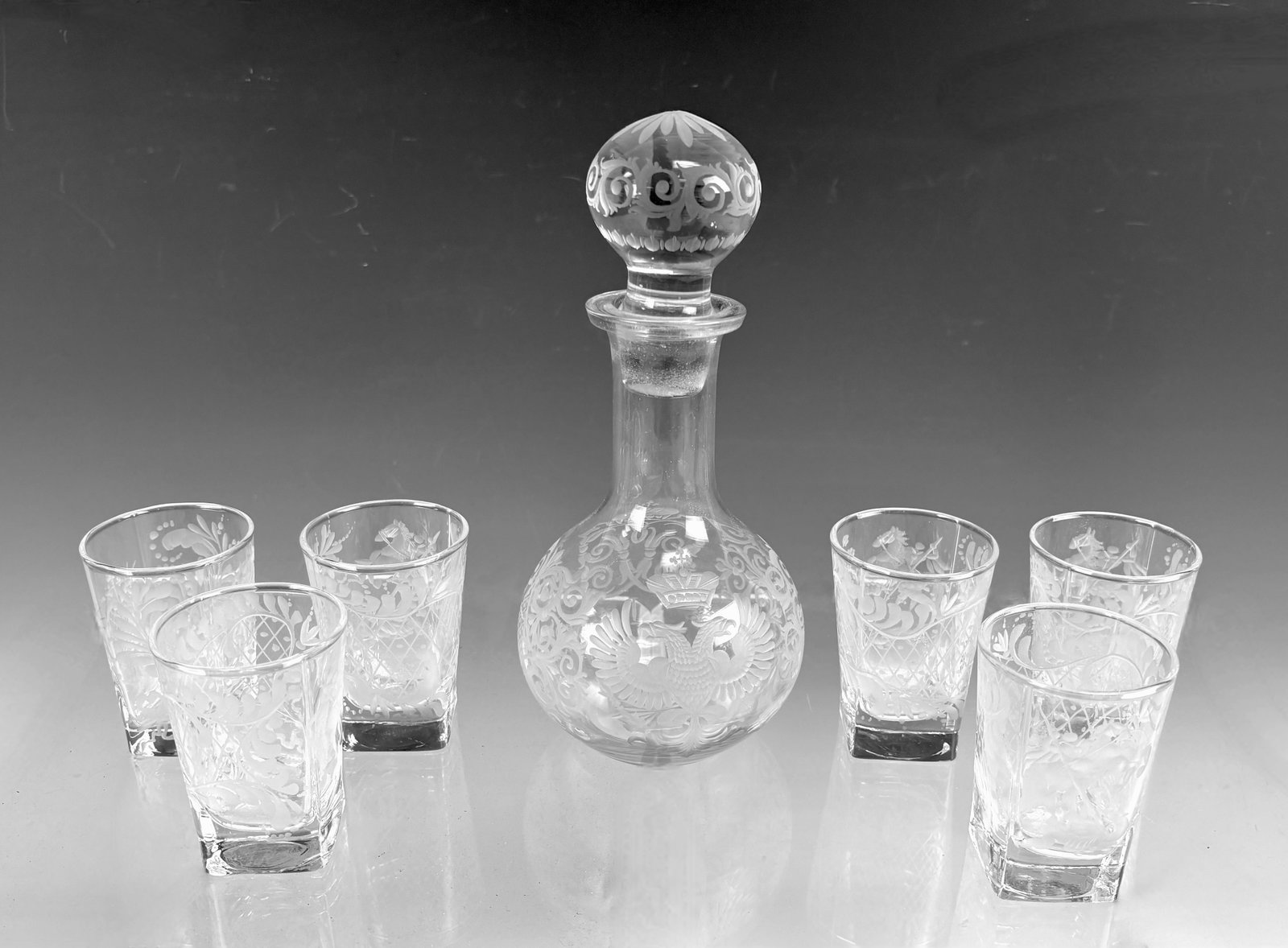 Russian Glass Decanter & 6 Glasses Liquor Set: Seven piece Russian liquor set consisting of a decanter with carved double eagle design with six ornately decorated shot glasses, very good condition, decanter 7.75" tall.Eligible for in-house