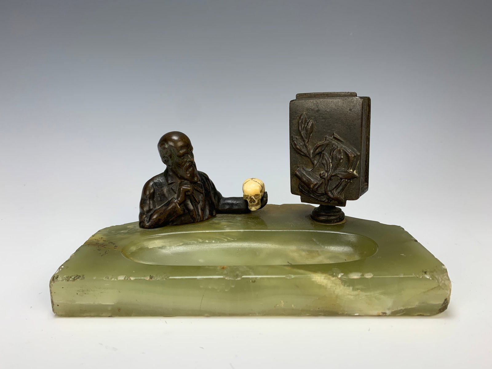 Bronze Figure w Skull Ashtray & Bronze Match Box: Circa 1900, smoking accessory having a bronze figure of a man holding a skull and a bronze match box on a green onyx tray, 7" x 4" X 4.25", good condition, tiny nicks on onyx.Eligible for in-house