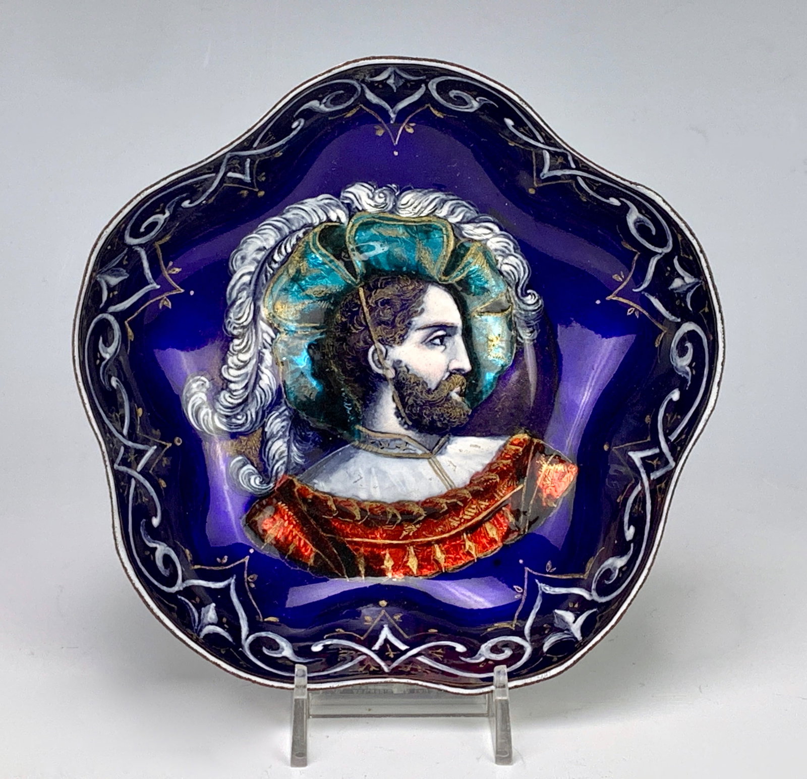 French Limoges Enameled Bowl C. 1890: Portrait of a bearded man with feathered hat against a blue enamel decorated body, unsigned, 2.25" x 6". Good condition.Eligible for in-house shipping (U.S. only). Please inquire.