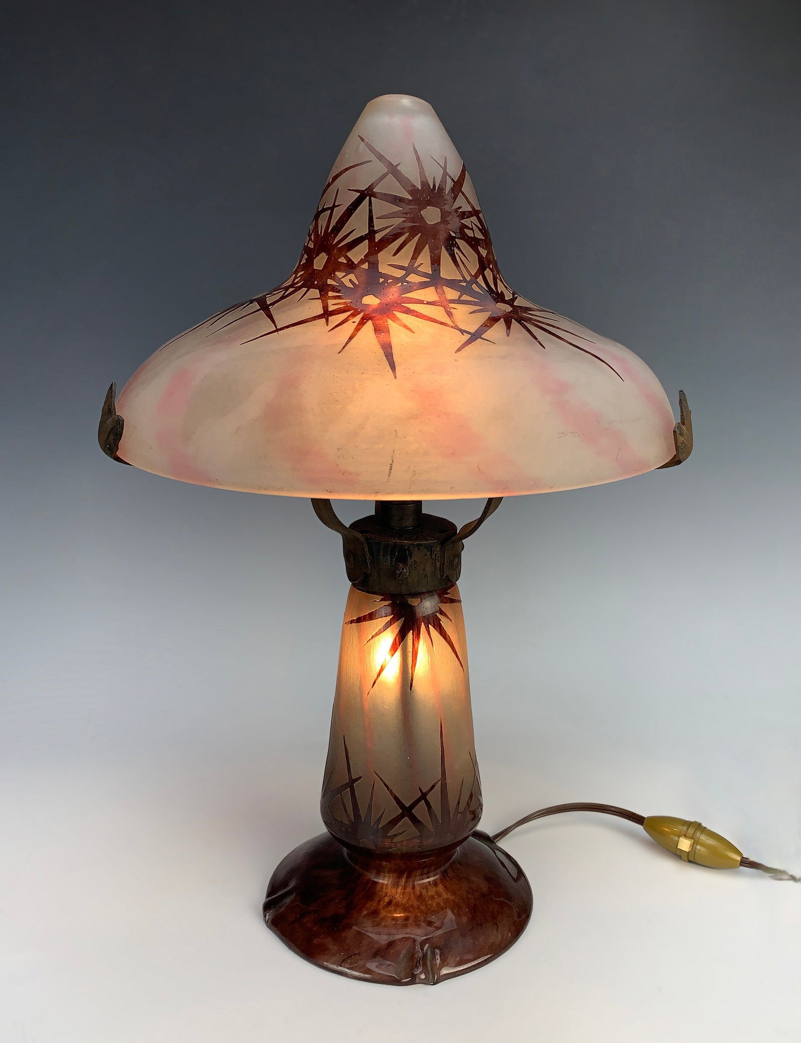 LeVerre Francais "Stars" Cameo Glass Lamp: Acid-etched cameo glass lamp with a stars pattern, mounted on a 3-arm wrought iron support. Signed with a candy cane mark. Circa 1920s. 15" tall x 9.5" diameter, good condition
