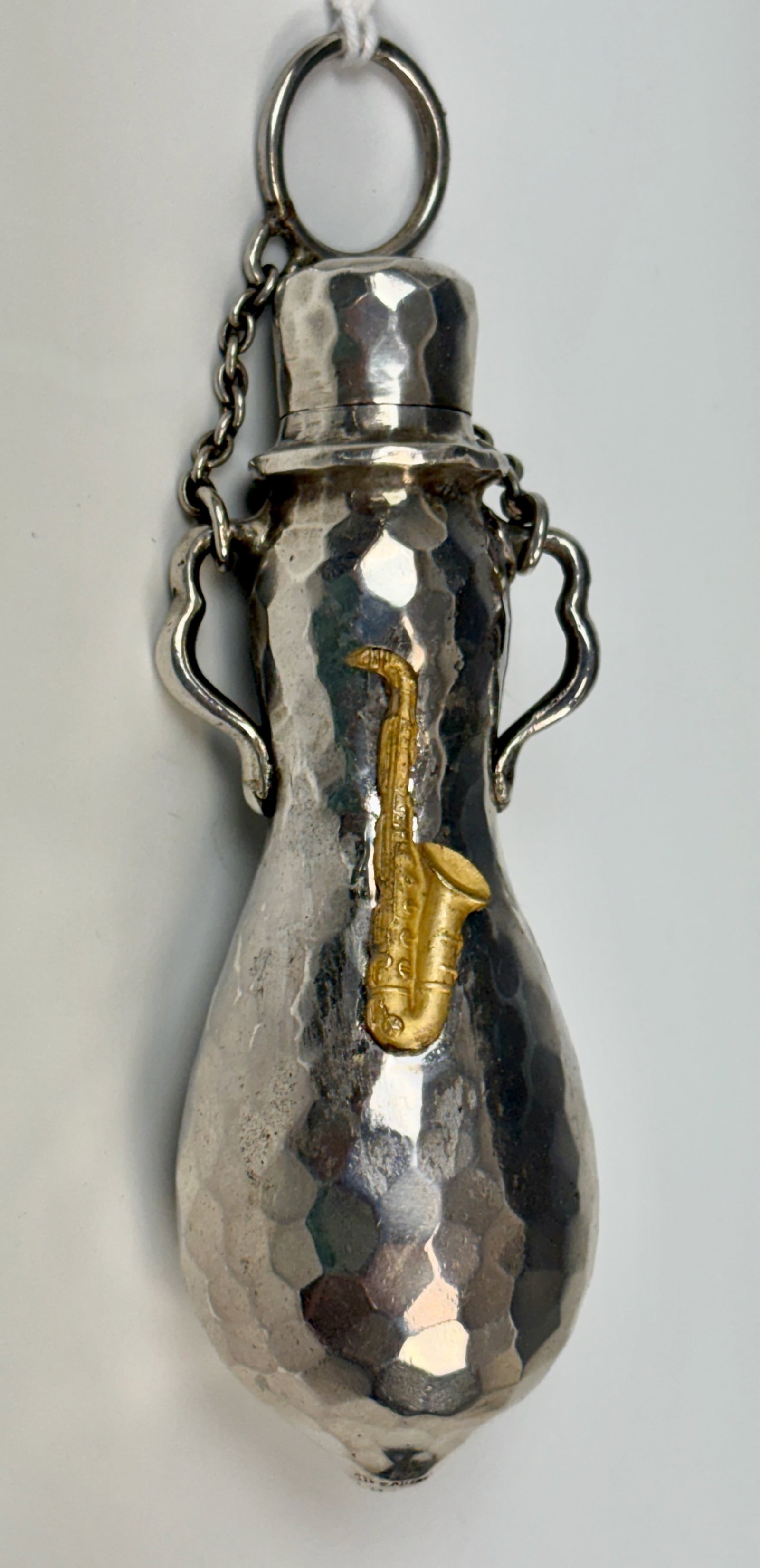 Tiffany & Co Sterling Mixed Metal Perfume Bottle: Unusual Tiffany & Co sterling silver and mixed metal hanging scent bottle, hand hammered with applied saxaphone in contrating metal, marked "Tiffany & Co 4910 Sterling 3729 M "(Moore), 54 grams, 4" x
