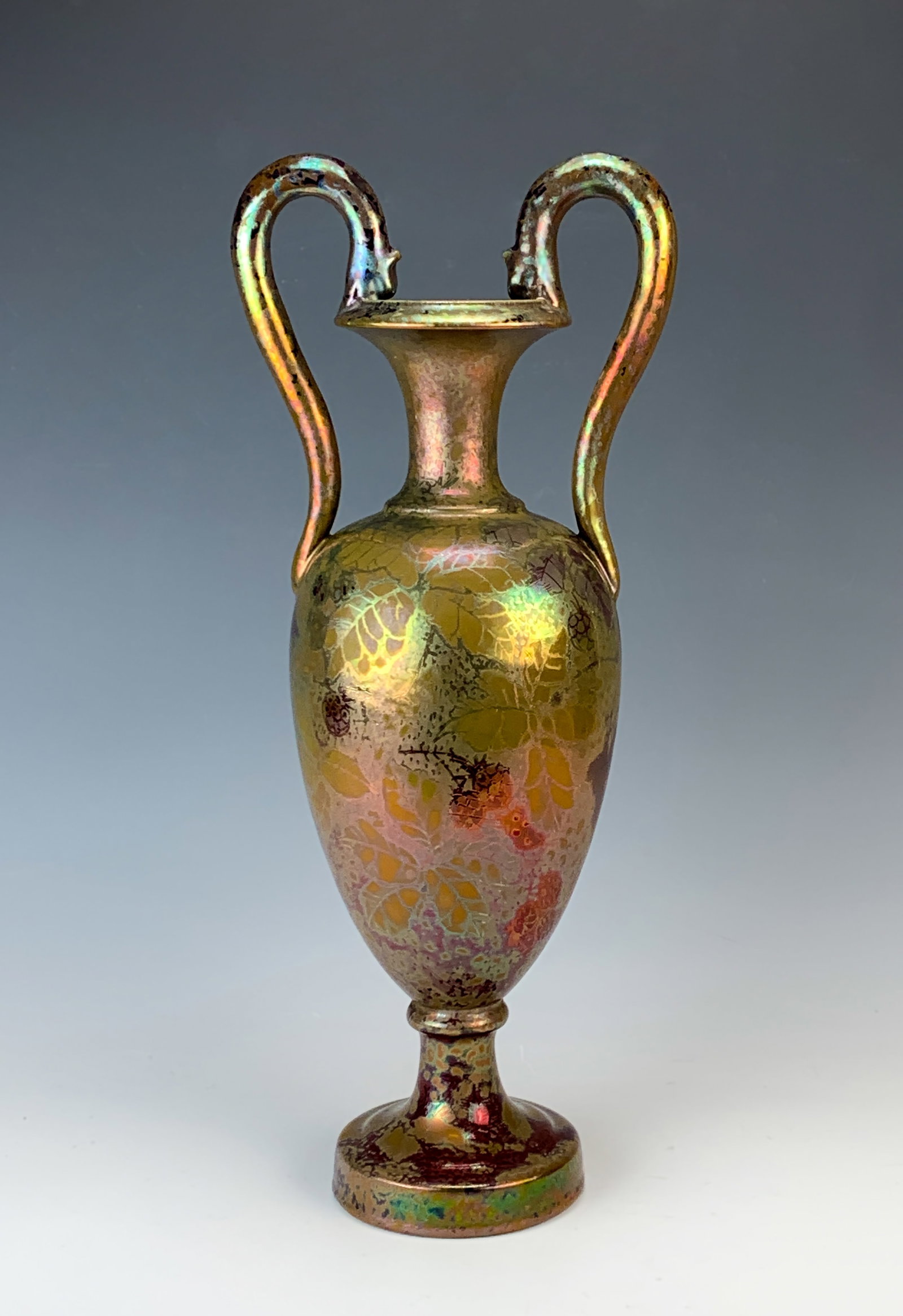 Rare Large Clement Massier "Berries & Leaves" Vase: Rare large Clement Massier "Berries & Leaves" iridescent double-handled vase with amazing colors of gold and red. The handles have grotesque heads grasping the rim. Signed on the bottom "Clement