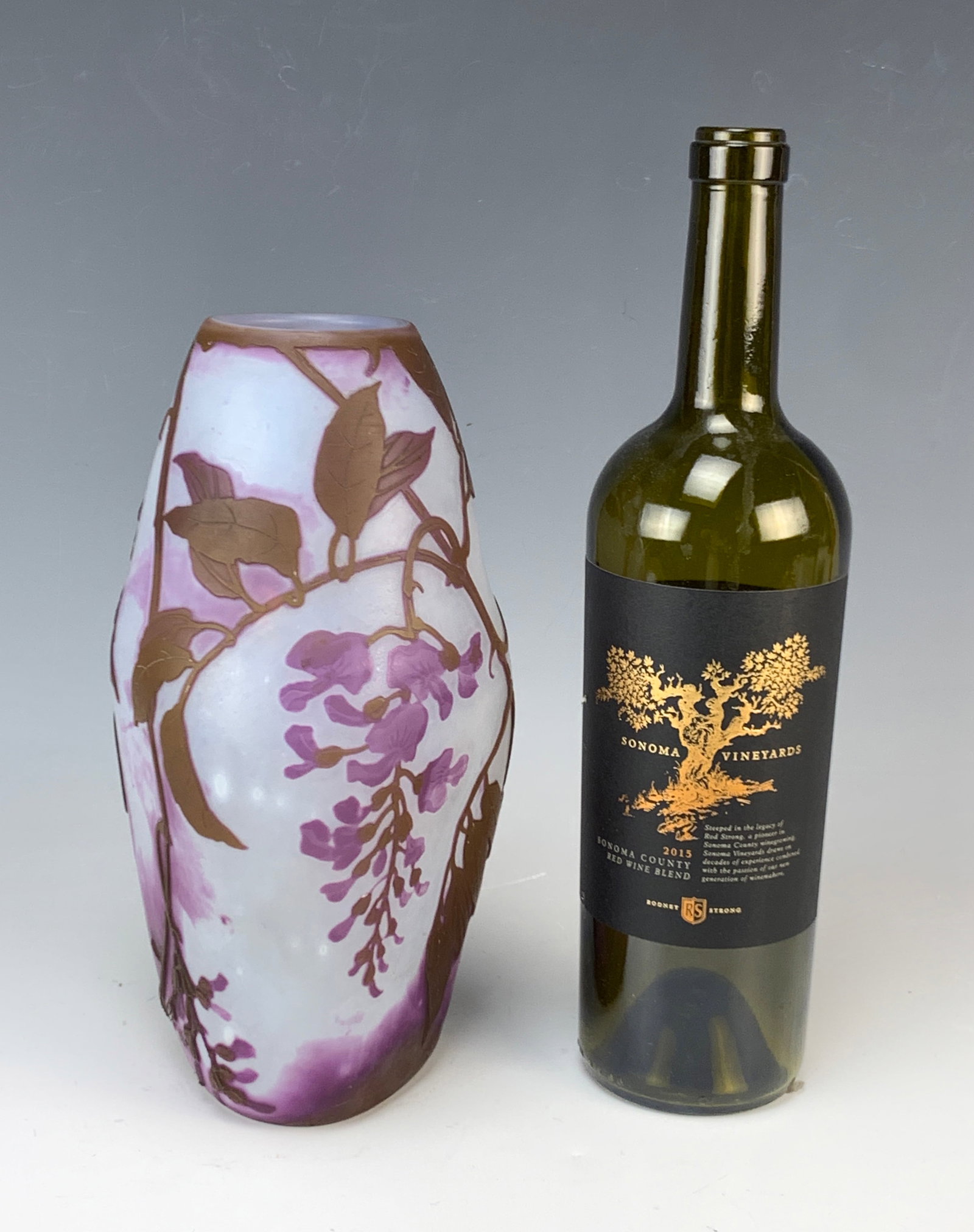 Le Gras Cameo Glass Vase Decorated with Wisteria: Beautiful Le Gras cameo vase with three irregular sides, decorated with violet purple wisteria against a white body. Signed "Le Gras" in cameo on the bottom side. 9 5/8" tall. Very good condition.