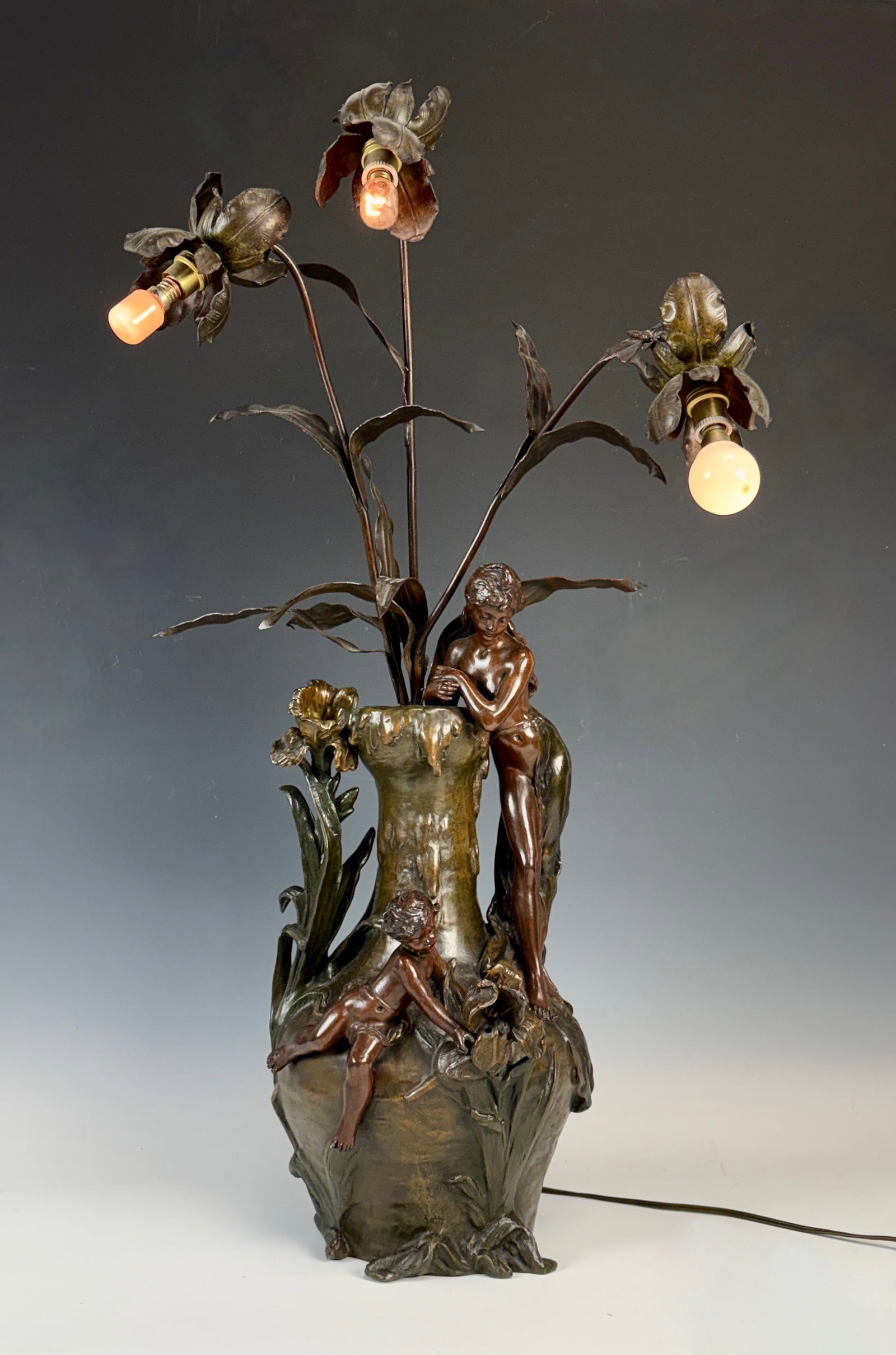 Hippolyte Moreau Allegory of Spring Figural Lamp: Hippolyte Moreau (France 1832-1926) Circa 1890, exceptional signed art nouveau bronze patinated metal lamp with semi nude figure and putti, with three arms with lights and decorated with foliage, one 