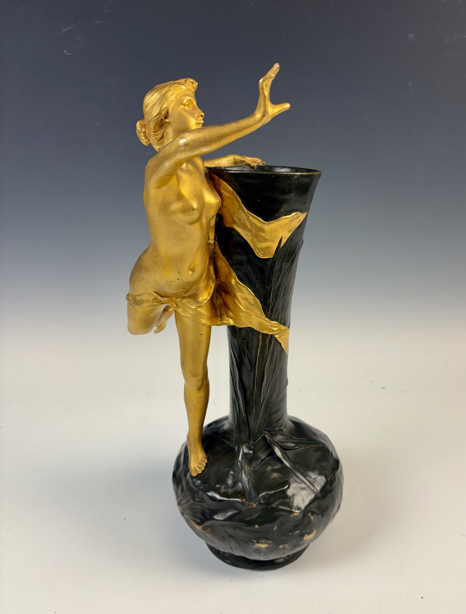 Antonio Bofil Nude Sculpture of Female Runner: Antonio Bofil (1876-1925) gilt bronze nude of a lady running along the base of the vase which has dark green patina decorated with foliage, signed "Bofil", very good condition, 13.5" tall.Eligible for