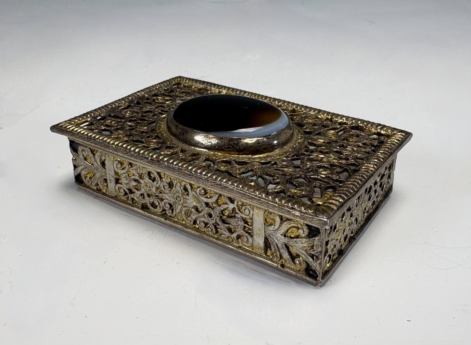 Continental Silver MOP & Agate Snuff Box: Late 19th Century, a continental silver snuff box with intricate pierced openwork over a layer of mother of pearl and set with an oval agate cabochon, has silver hallmarks, 2.6" x 1.75" x .75", very g