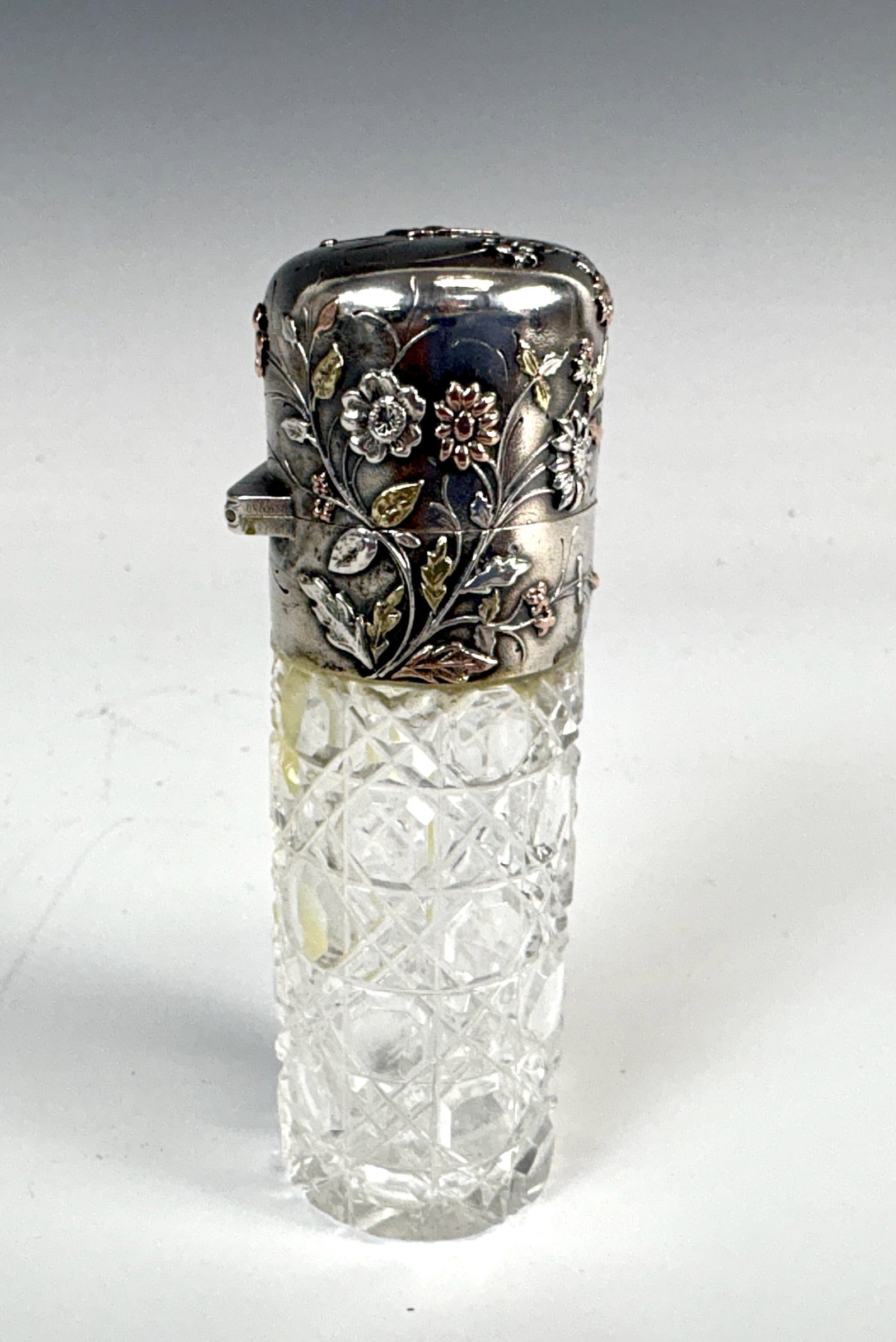 Cut Glass & Mixed Metal Victorian Scent Bottle: Late 19th Century, probably French, cut glass Victorian scent bottle with cross hatched pattern and a mixed metal silver top with gold florals and a flying bird at top, with two silver hallmarks, minu