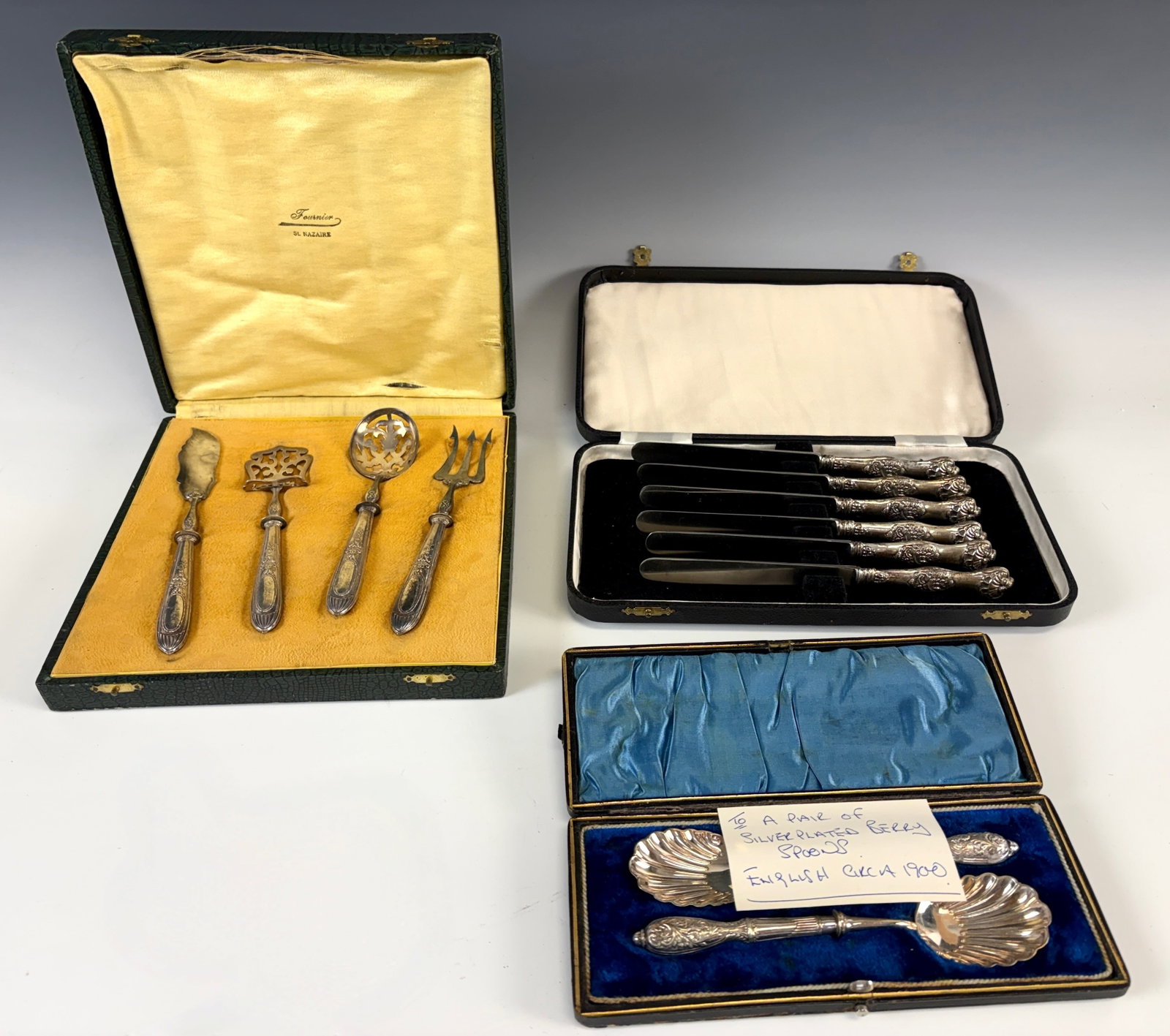 3 Sets Display Boxed Silver Serving Pieces: Circa 1900, three sets serving pieces, one with 6 knives with sterling silver handles and stainless steel blades, with 4 condiment pieces with sterling handles and stainless steel, with a pair of silv