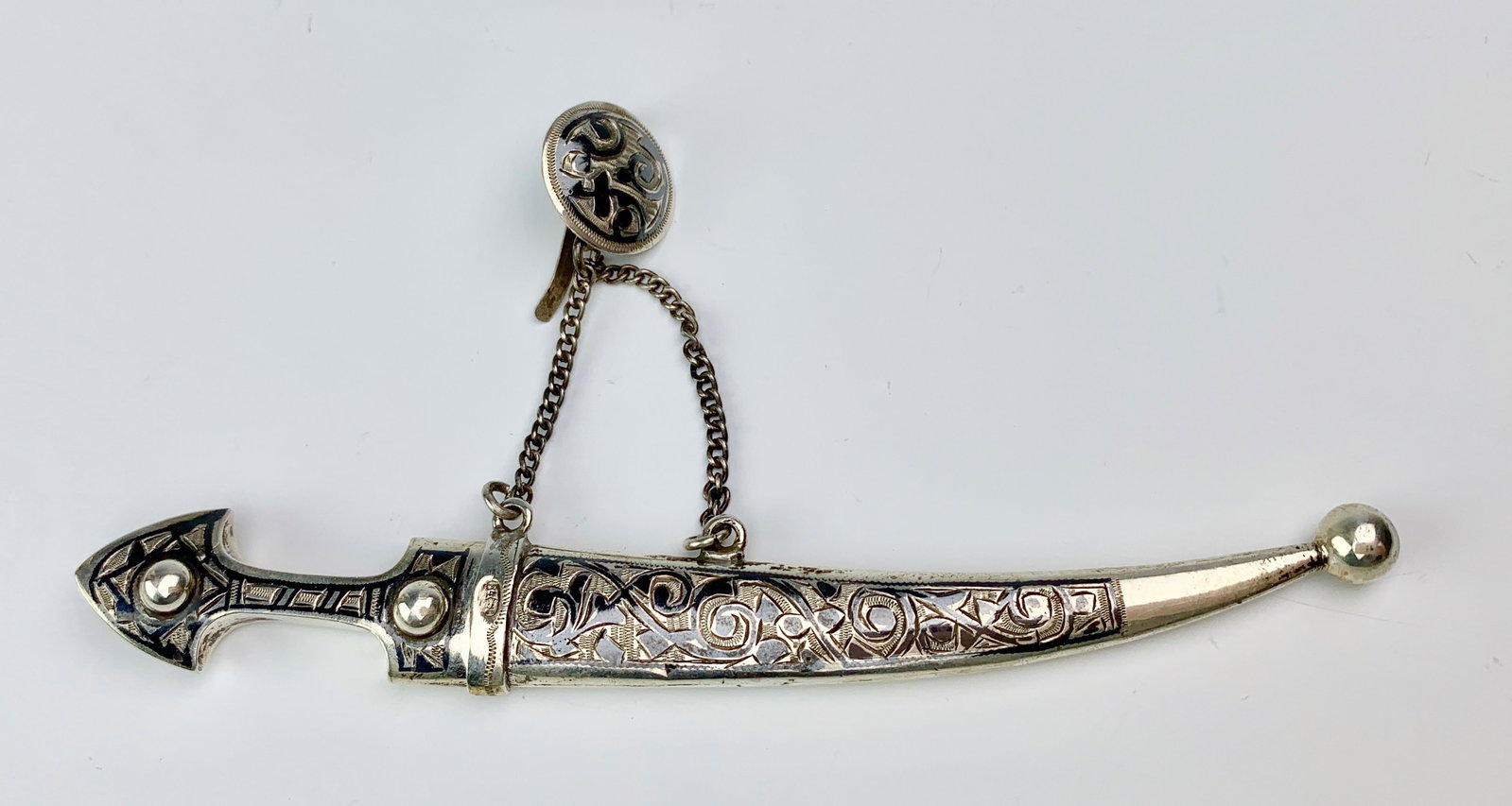Russian Niello Miniature Sword w/ Chain & Clasp: Circa 1900, silver with black enamel (niello) scabbard and sword, connected by 2 chains to a circular silver and niello clasp, Russian hallmarks on back side on round clasp, very good condition, 5" le