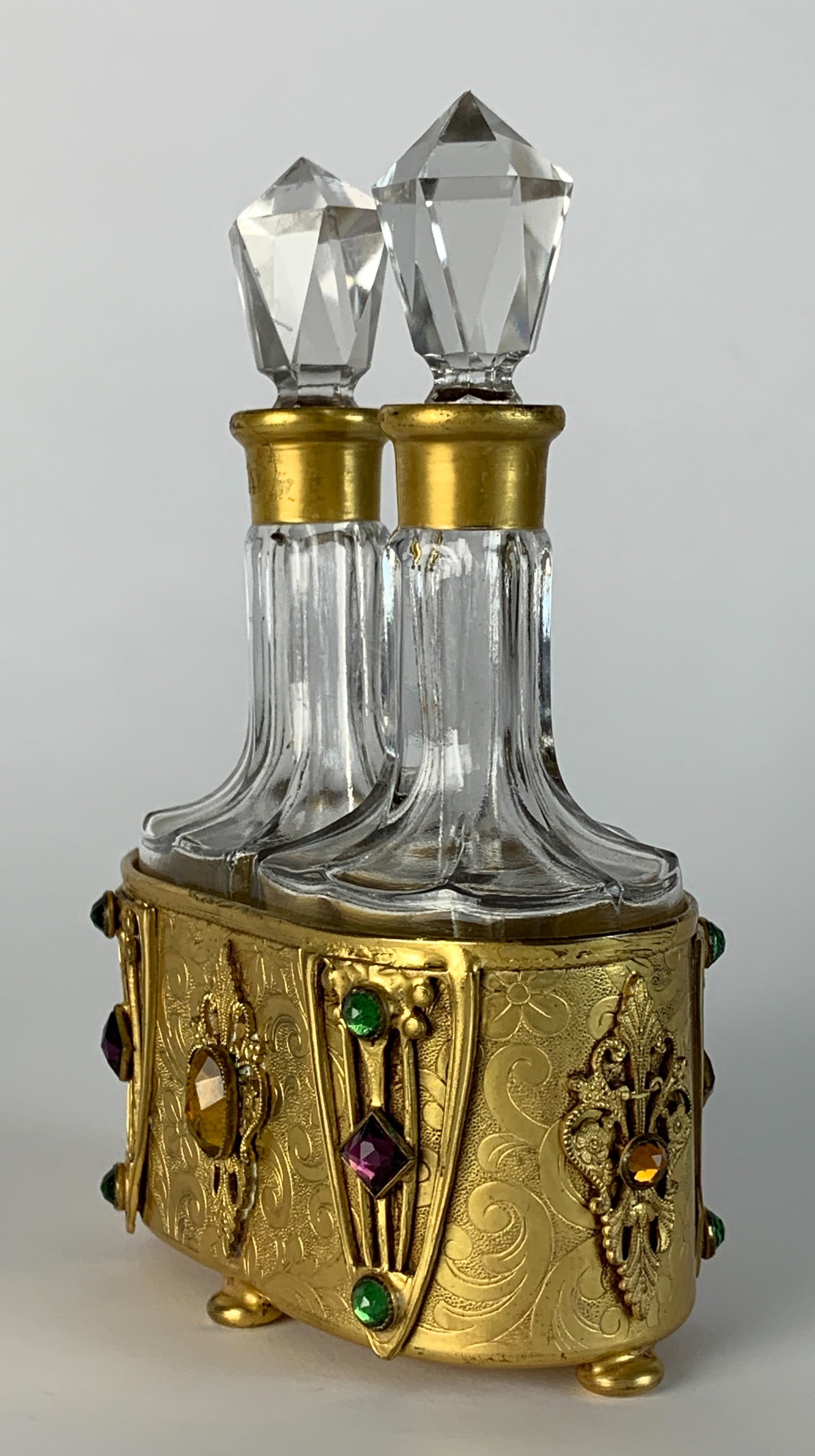 Apollo Double Perfume Bottles w Jeweled Holders: Circa 1900, double perfume bottles in gilt metal frame set with colored jewels, numbered 2772, holder signed on bottom "Apollo", 5" tall, very good condition