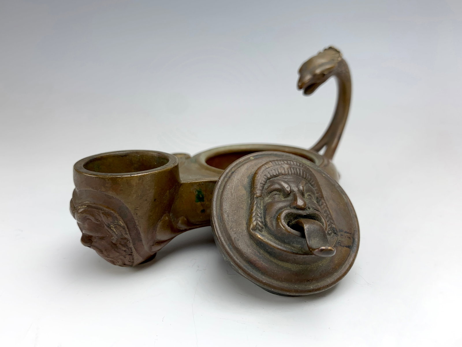F. Barbedienne Bronze Oil Lamp Style Candlestick: Circa 1850. Ferdinand Barbedienne (1810-1892). Shaped like an oil lamp is this candlestick made in France and signed F. Barbedienne. The handle in shape of a bird's head, has a circular lid with an un