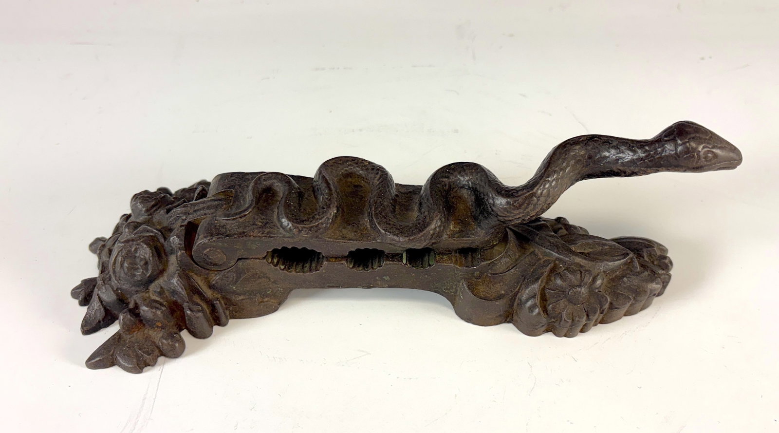 C 1880 Snake Iron Cork Presser: A most unusual cast iron snake-form cork presser used by pharmacies in the late 19th century to seal bottles of medicinal preparations. Corks were pressed and molded to properly fit bottle tops; this