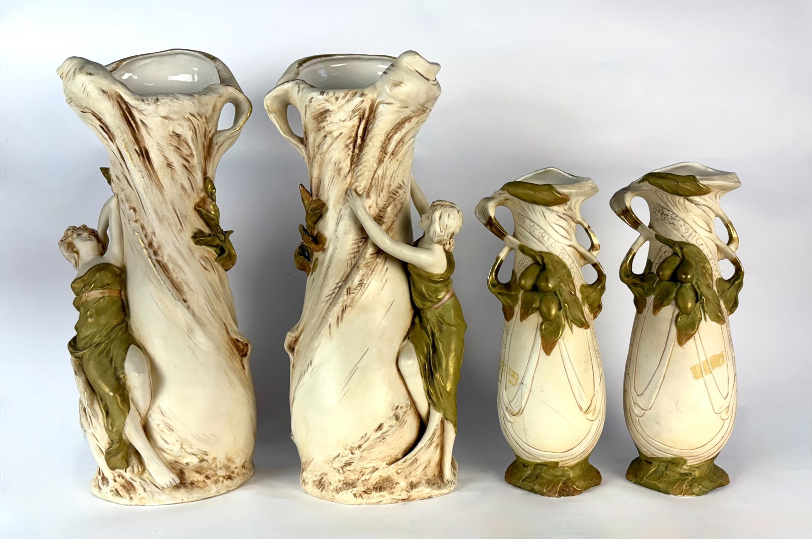 Group of 4 Art Nouveau Royal Dux Vases: Circa 1900, lot consists of 4 Royal Dux vases, two pairs with cream colored bodies, the larger pair with female figures grasping the vases which appear to be modeled as tree trunks, the smaller pair w