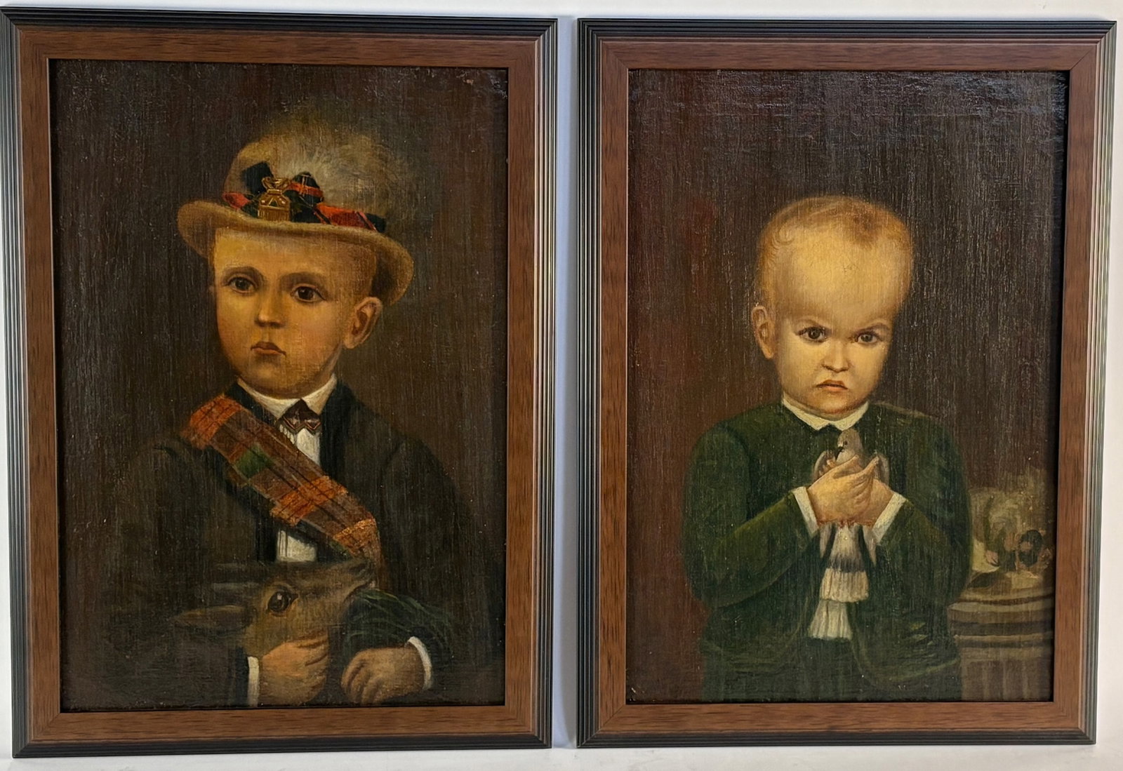 Pair Antique Folk Art Portrait Paintings c.1800's: Early 19th century, oil on canvas laid down on board, 2 portraits of young boys, one with a bowler hat and a deer, the other showing a boy with enlarged forehead with a bird. Unsigned but on reverse b