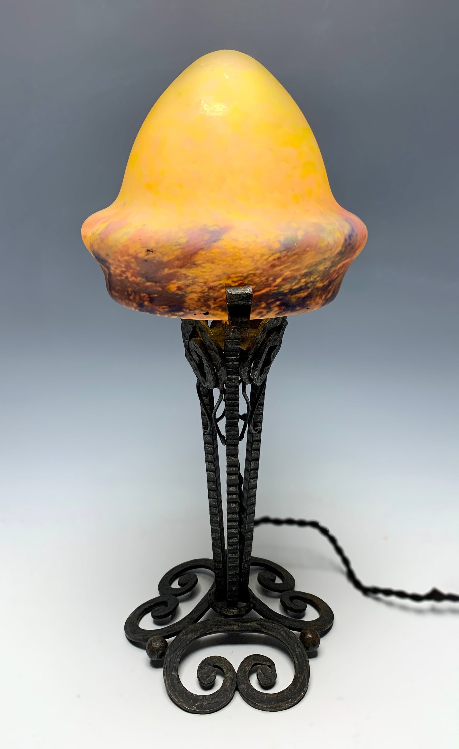 Art Deco Mottled Glass & Iron Lamp: Circa 1930, French art deco art glass lamp with domed shade with yellow, blue and red border mounted upon a wrought iron base, unsigned, rewired with on/off switch, 16"tall, very good condition
