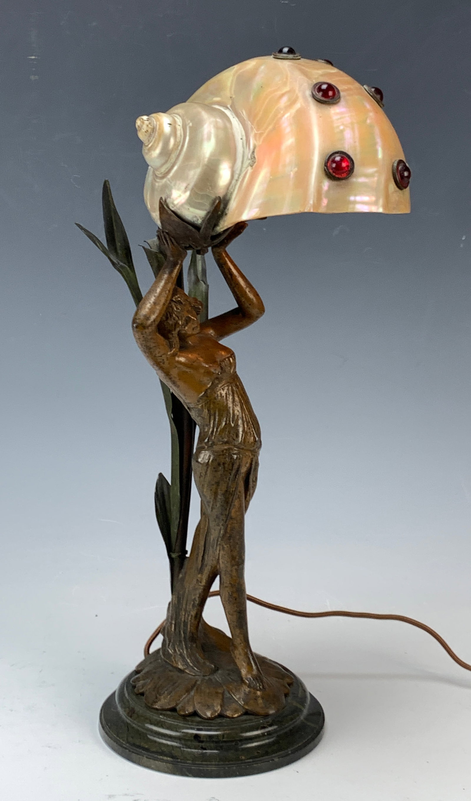 Art Nouveau Figural Lamp w Shell & Jewels: Circa 1900, fine Art Nouveau lamp with a young woman supporting a sea shell embellished with garnet colored cabochon jewels, mounted on green marble base. Tip of one leaf missing otherwise good condit