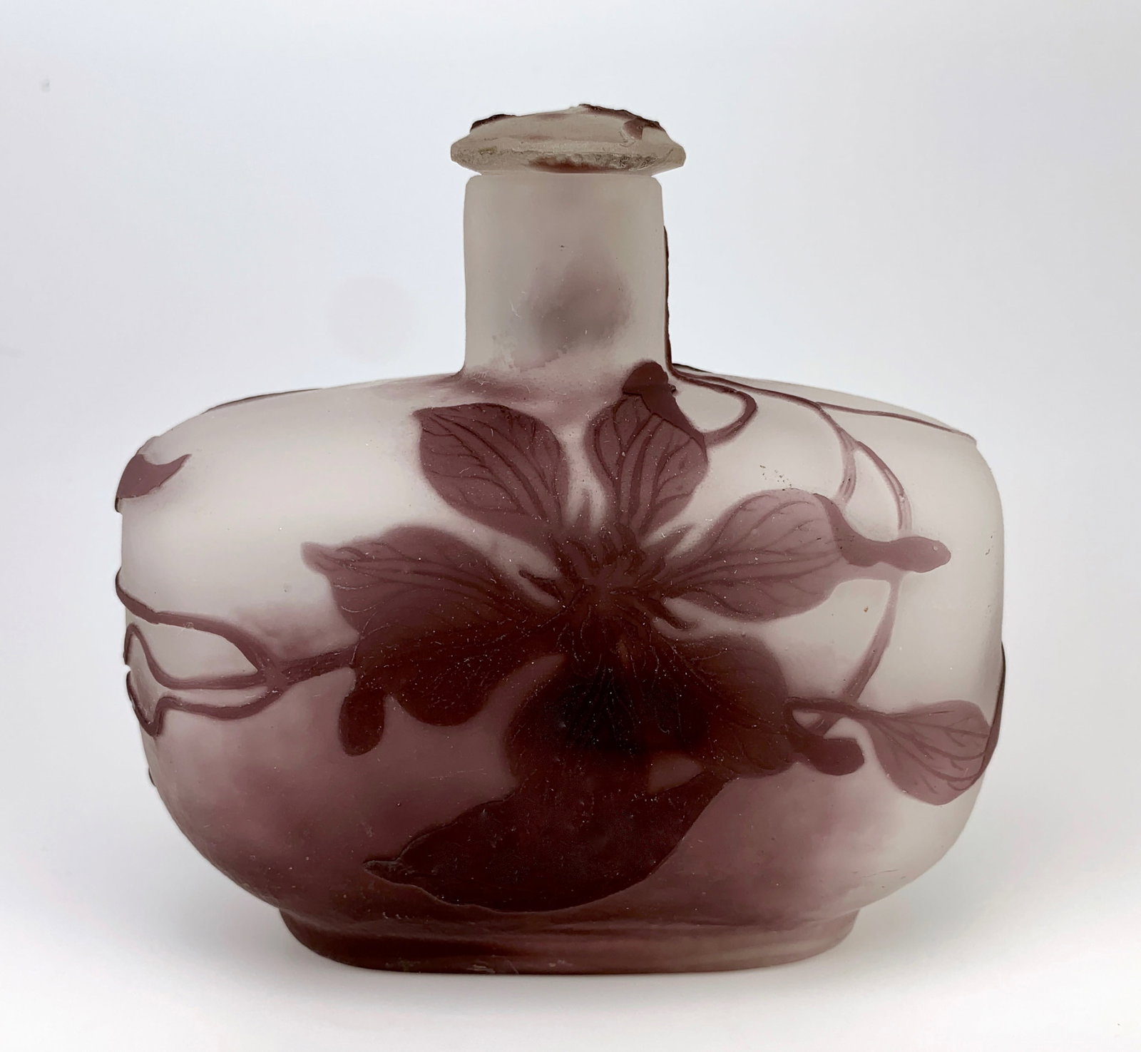 Galle Cameo Glass Perfume Bottle: Circa 1900, Galle cameo art glass perfume bottle with stopper, lavender carved floral motif layered over a white frosted body, signed "Galle", very good condition, 4" x 4.25"