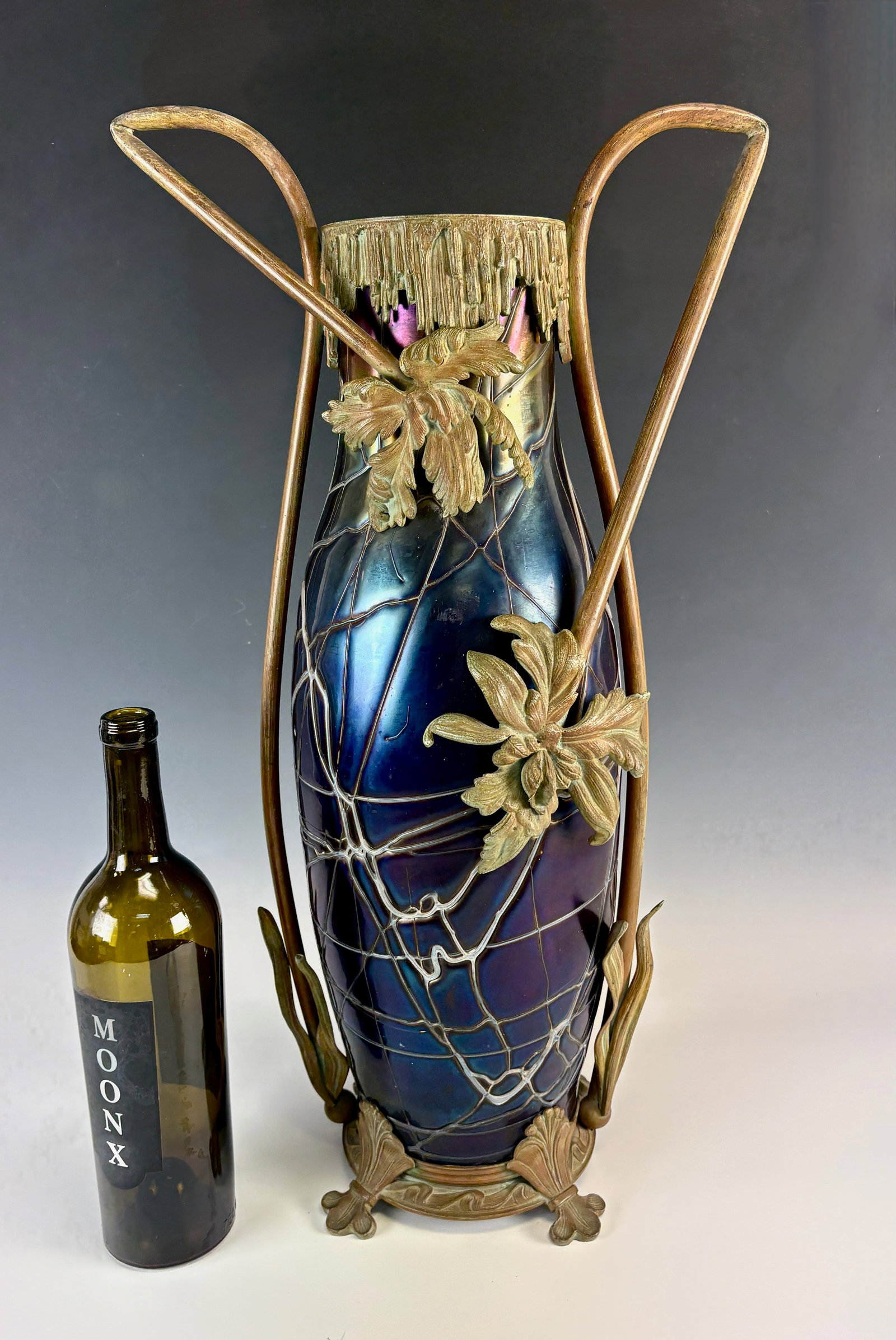 Monumental Kralik Art Glass & Bronze Vase: Circa 1900, Art nouveau period, Bohemia, impressive large purple iridescent art glass vase with veining throughout encased in a bronze frame with iris blooms and foliage as handles, the neck with bron