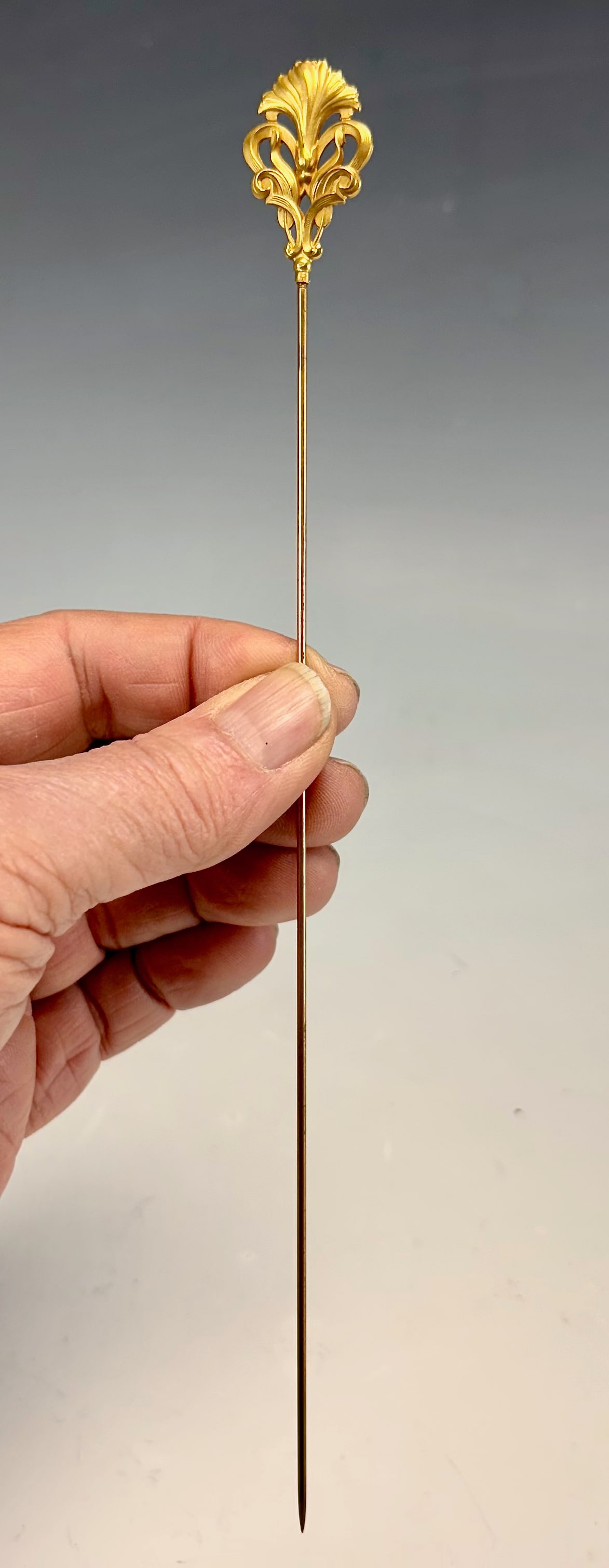 18K Yellow Gold Ornate Hatpin: Hatpin with a fancy head with hallmarks,tested 18K gold weighing 6 grams total weight, pinstem is not gold, very good condition.