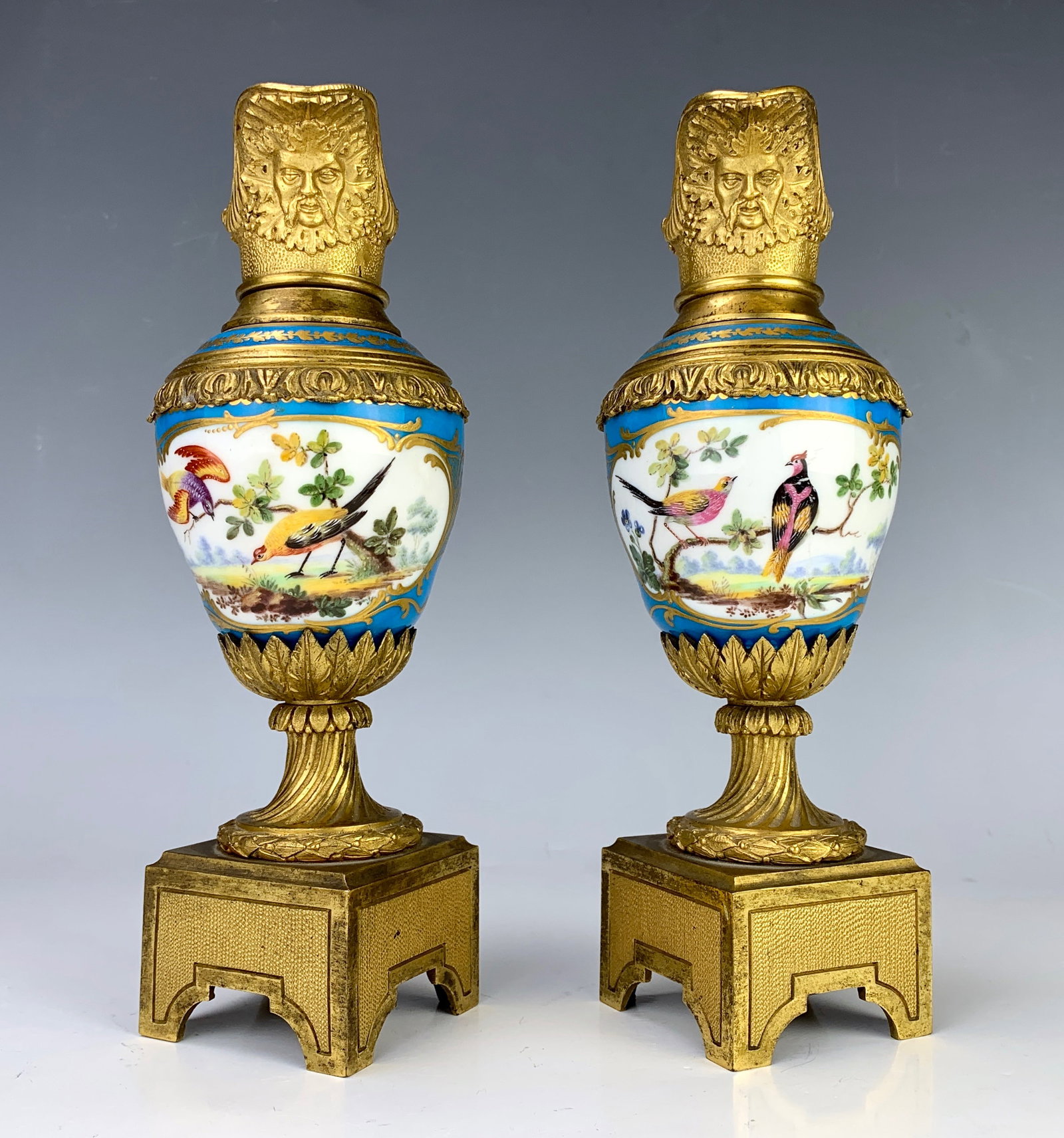 Pair of Sevres Louis XV Ornamental Ewers: Circa 1880, pair of beautiful Sevres porcelain ewers with scenes of birds on terraces on a celestial blue backgrounds with gilt bronze ornaments and heads of Bacchus on each, very good condition, 9.25