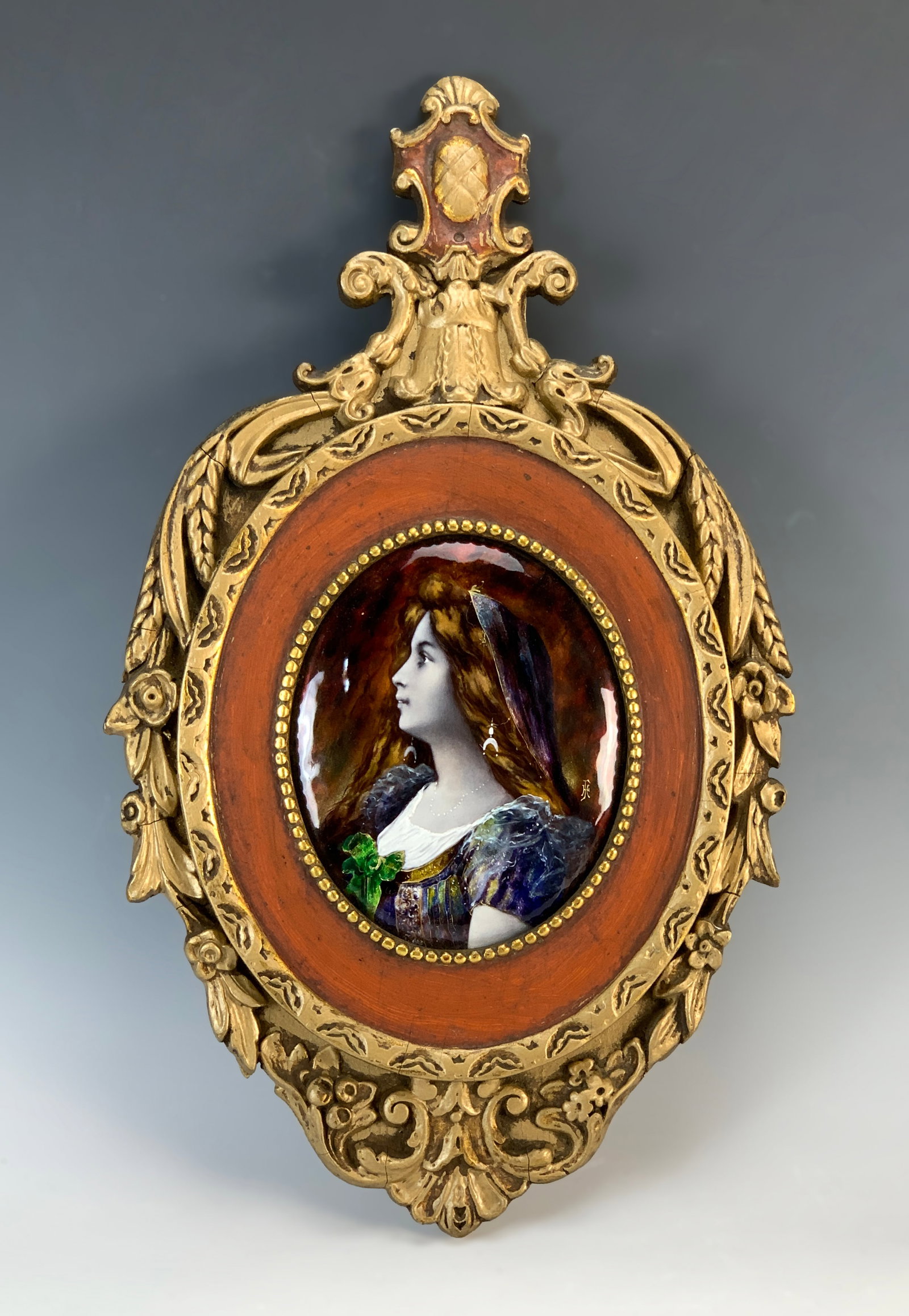 Limoges Enamel Portrait Of a Beauty Signed: Circa 1900. Finely painted Limoges oval enamel portrait of a beautiful woman wearing a pearl necklace. Artist's initials "T" over "H." Mounted in its original gilt oval frame with painted and red inne