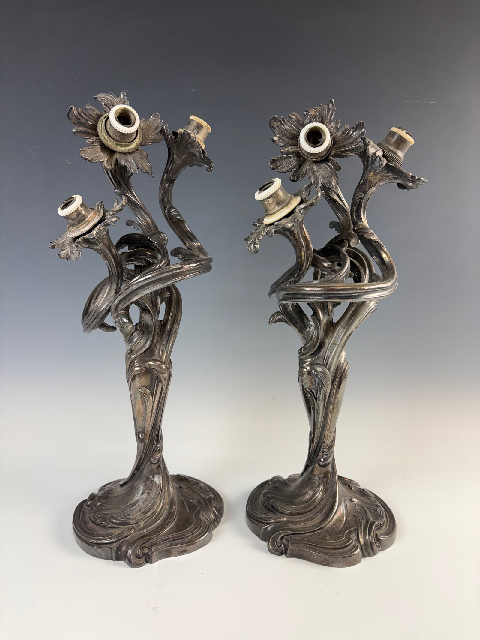 Pair Ornate French Silverplate 3 Arm Candelabra: Circa 1900, two highly decorative art nouveau ornate silver plated candelabras having 3 arms, one with break in arm, fair condition, 16" tall