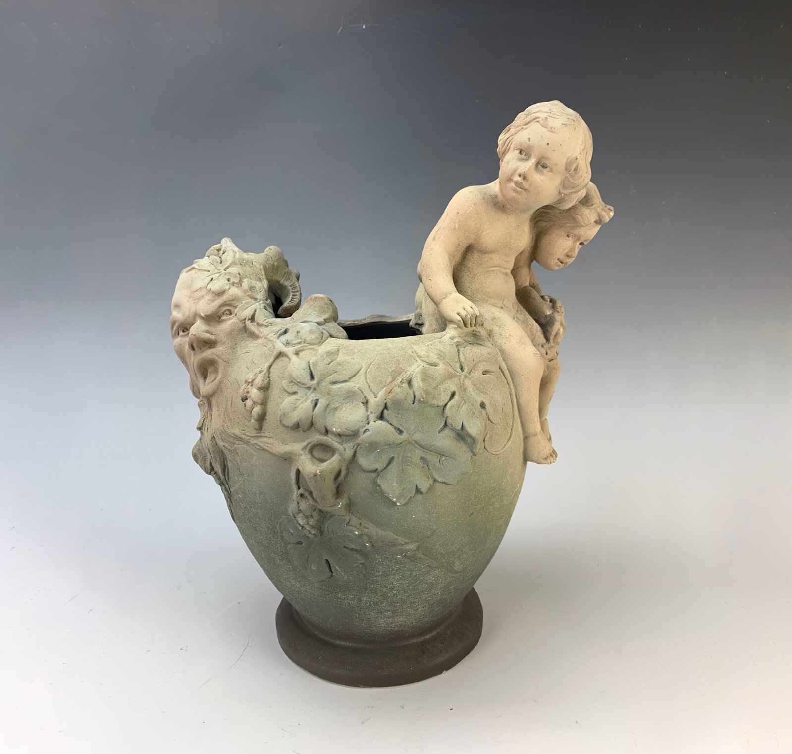 Charenton Art Nouveau Pottery Vase: Circa 1900, period art nouveau figural art pottery vase depicting nude children and a man's grotesque face with horns on opposite rim with foliage, signed on bottom "Charenton", 11: tall, very good co