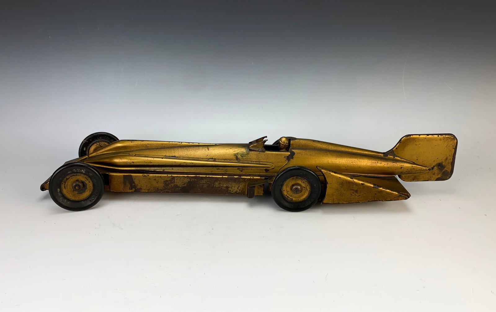 Kingsbury Golden Arrow Windup Steel Racing Car: Circa 1930, wind up toy car modeled after the Golden Arrow driven by Major Henry Segrave when he set his final speed record of 231.45 MPH at Daytona Beach on March 11, 1929, with four rubber tires mar