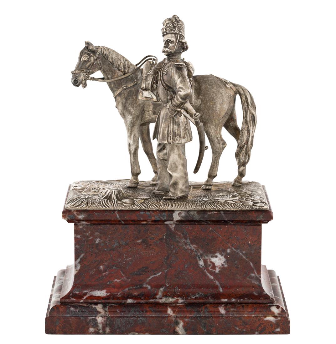 A RUSSIAN SILVER SCULPTURE OF A COSSACK AND HIS HORSE,: A RUSSIAN SILVER SCULPTURE OF A COSSACK AND HIS HORSE, JOHANN OLSONIUS FOR GRACHEV, SAINT PETERSBURG, 1890 featuring a dismounted figure of a cossack leaning an elbow on his steed, set on a realistica