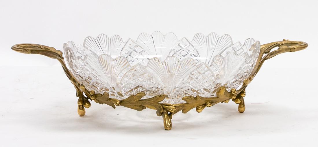A CUT CRYSTAL CENTERPIECE WITH ORMOLU BRONZE BASE, LATE: A CUT CRYSTAL CENTERPIECE WITH ORMOLU BRONZE BASE, LATE 19TH-EARLY 20TH CENTURY cut in a flower pattern with scalloped edges, on circular foot, supported by two-handled bronze base formed as enterlaci