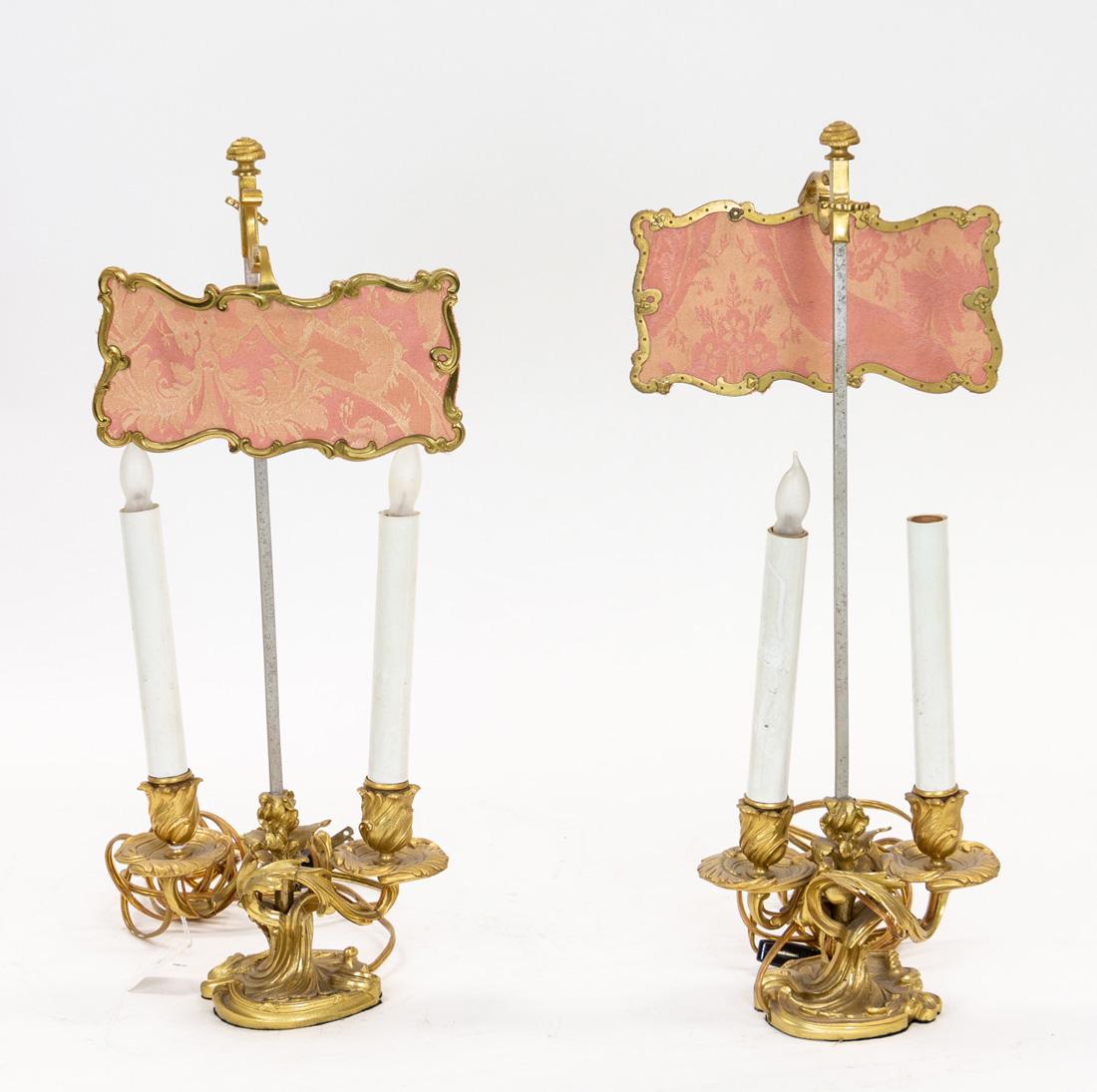 A PAIR OF BEDSIDE ORMOLU BRONZE CANDELABRA, EARLY 20TH: A PAIR OF BEDSIDE ORMOLU BRONZE CANDELABRA, EARLY 20TH CENTURY the two-light candelabra on rocaille bases, with screens, electrified; overall height of each: 49 cm (19 1/4 in.)