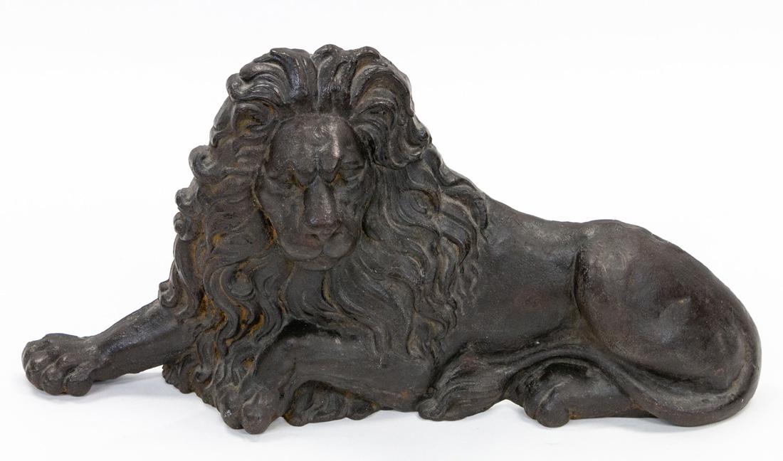 A BRONZE ANDIRON, EARLY 20TH CENTURY: A BRONZE ANDIRON, EARLY 20TH CENTURY formed as a recumbent lion; height: 35 cm (13 3/4 in.), length: 70.5 cm (27 3/4 in.)