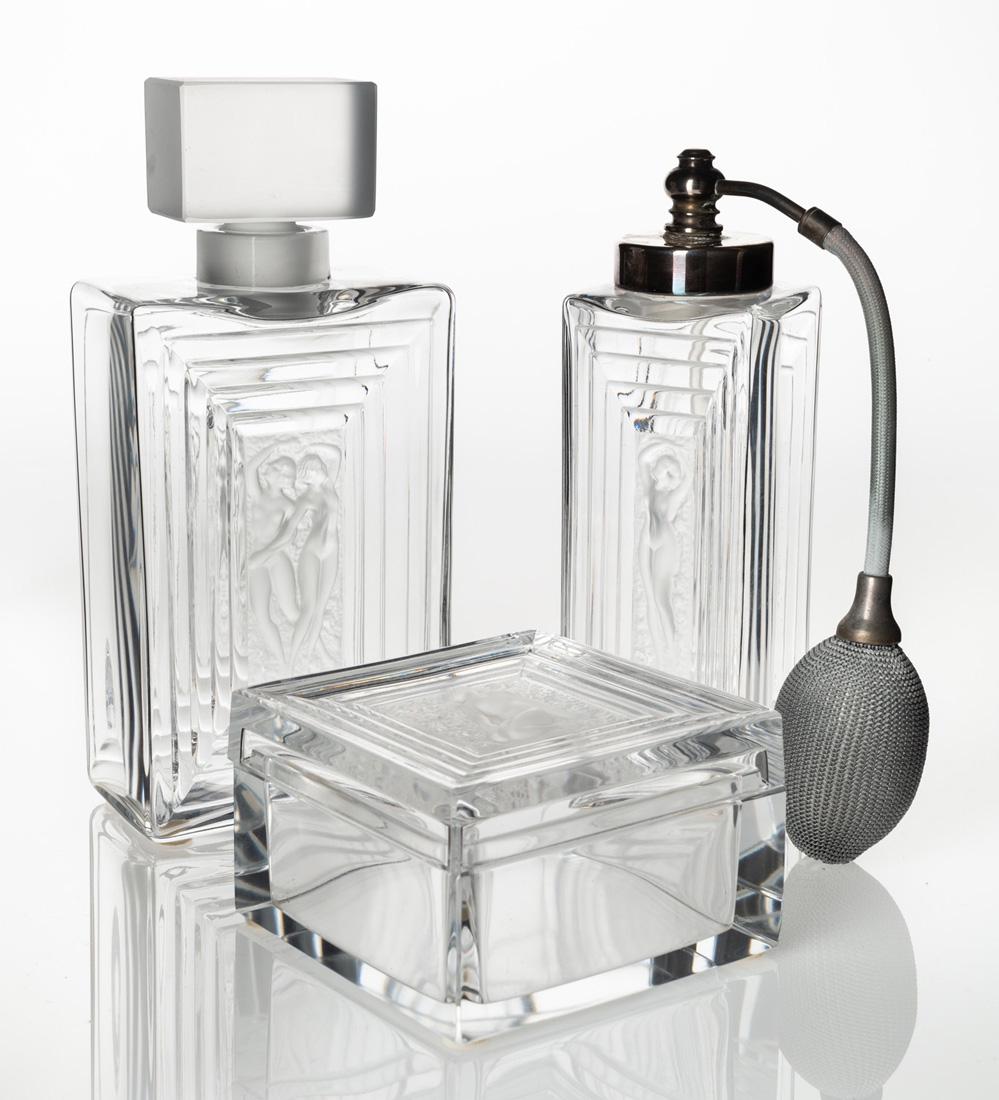 A LALIQUE 'DUNCAN' GARNITURE DE TOILETTE SET OF THREE: A LALIQUE 'DUNCAN' GARNITURE DE TOILETTE SET OF THREE CONTAINERS, DESIGNED 1931, PRODUCED CIRCA 1950S comprising: a) a Duncan No. 1 clear glass atomizer with frosted centerpiece featuring a dancing wo