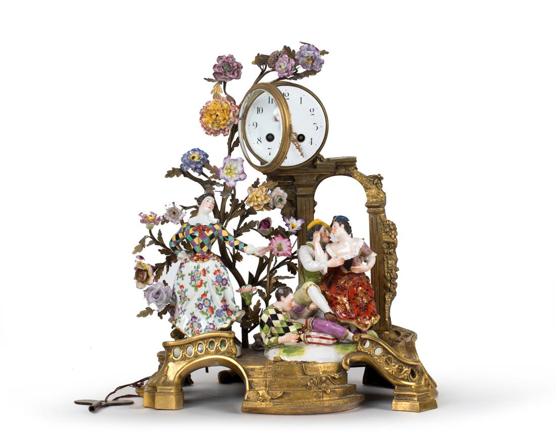 A DRESDEN PORCELAIN-MOUNTED ORMOLU CLOCK, EARLY 20TH: A DRESDEN PORCELAIN-MOUNTED ORMOLU CLOCK, EARLY 20TH CENTURY the clock supported by a pair of columns, the base modelled as a staircase, with Roman numerals surrounding the enamel clock face, with ine