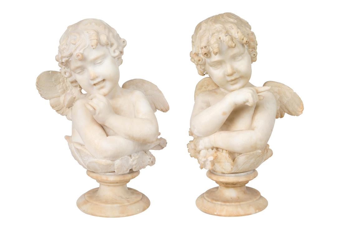 A PAIR OF ALABASTER PUTTI, LATE 19TH CENTURY: A PAIR OF ALABASTER PUTTI, LATE 19TH CENTURY shown pointing at one another, holding flowers, emerging from a head of cabbage, each atop circular baluster base; height of each not including base: 41 cm