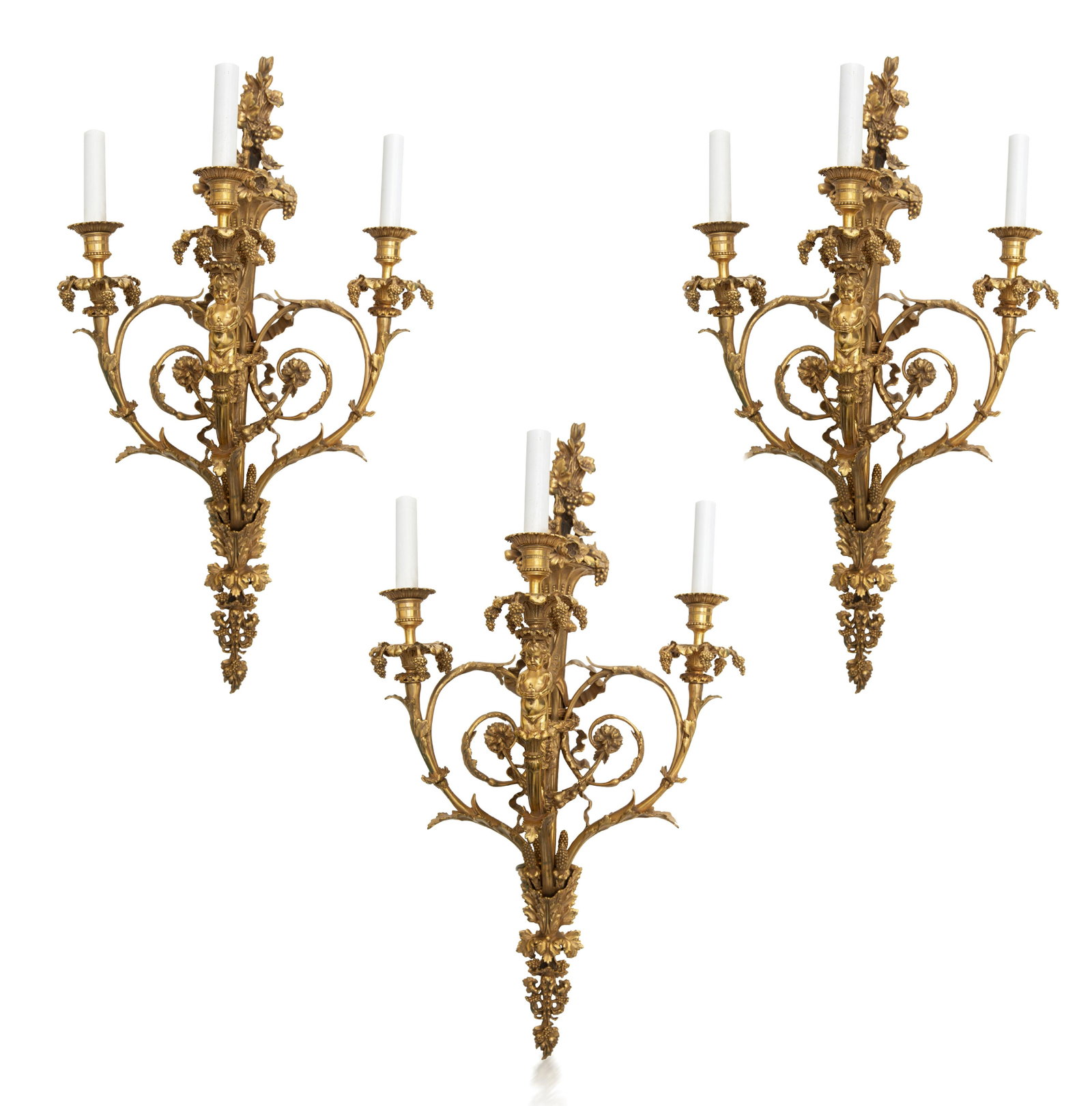 A SET OF THREE ORMOLU CANDELABRA WALL MOUNTS, LATE: A SET OF THREE ORMOLU CANDELABRA WALL MOUNTS, LATE 19TH-EARLY 20TH CENTURY comprising of a trio of three-light candelabra modelled as acanthus leaves and berries, with a cherub in the center, electrif