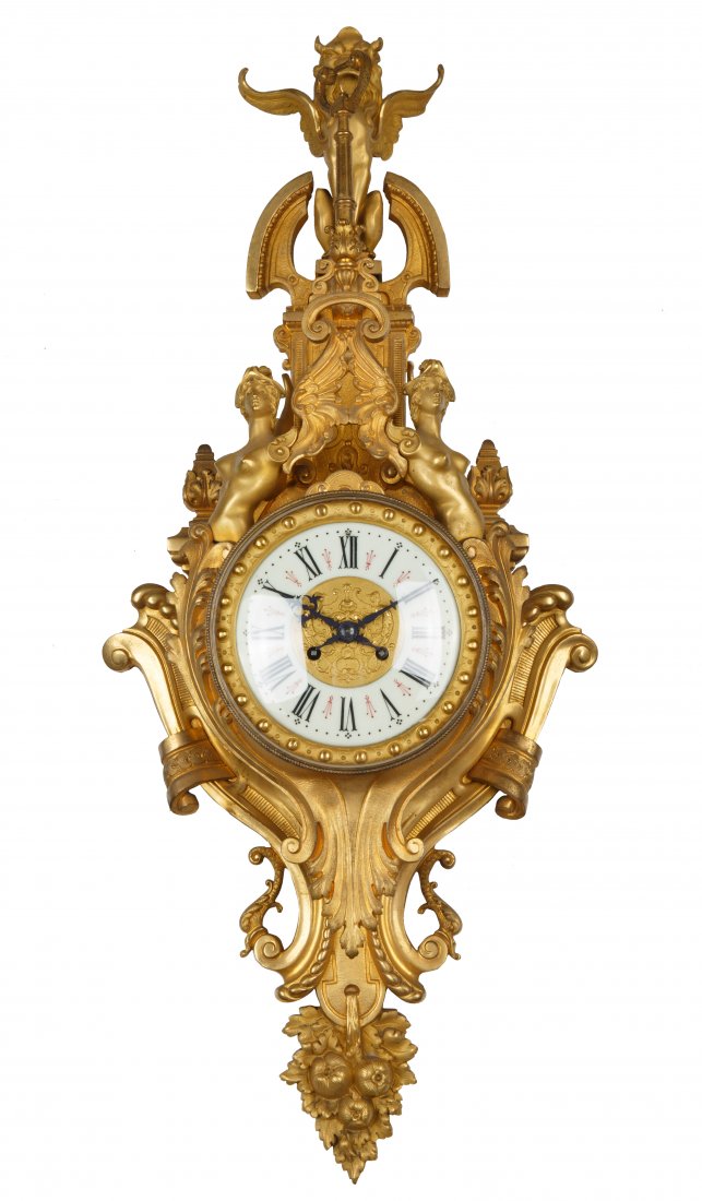 LATE 19TH CENTURY ORMOLU VINCENTI ET CIE CLOCK: LATE 19TH CENTURY ORMOLU VINCENTI ET CIE CLOCK the porcelain face set in tiered foliate scrolled brass setting, a winged lion sits atop, two nude caryatids flank either side of the face, terminating f